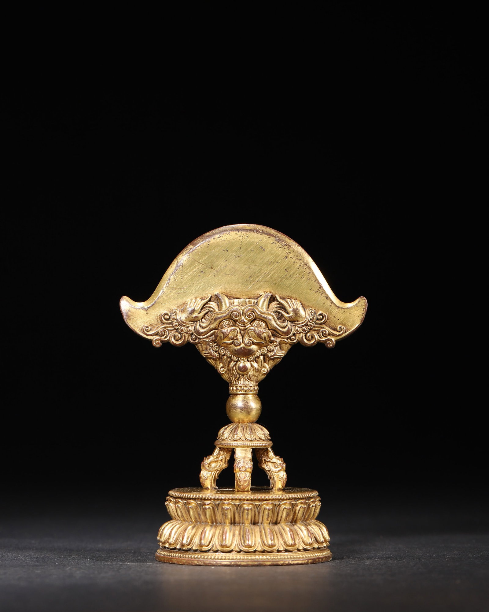 A GILT-BRONZE AXE AND VAJRA RITUAL IMPLEMENT: A gilt-bronze ritual implement combining an axe-form upper element with a five-pronged vajra below. W. 7.5 cm; Ht. 10.5 cm; Wt. 300 g.
