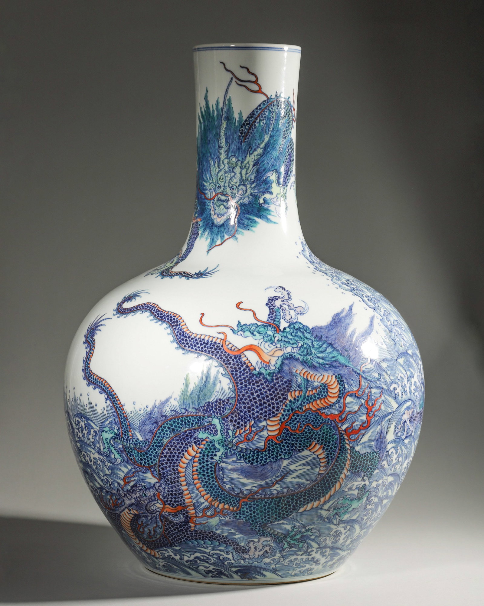 A BLUE-AND-WHITE AND POLYCHROME 'DRAGON AND WAVE' PORCELAIN VASE (1 of 7)