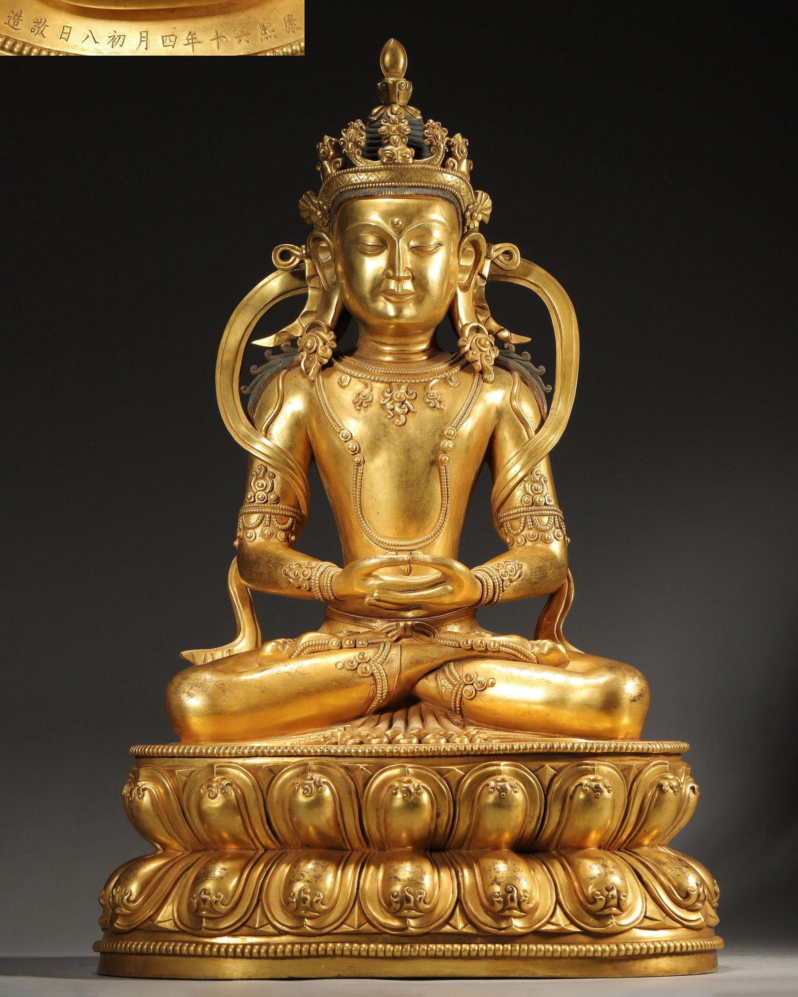 A GILT-BRONZE FIGURE OF AMITAYUS: A gilt-bronze figure of Amitayus. The figure bears a dated inscription reading 'Kangxi 60th Year, 4th Month, 8th Day, Jing Zao'. L. 28 cm; W. 20 cm; Ht. 46 cm; Wt. 13,750 g.