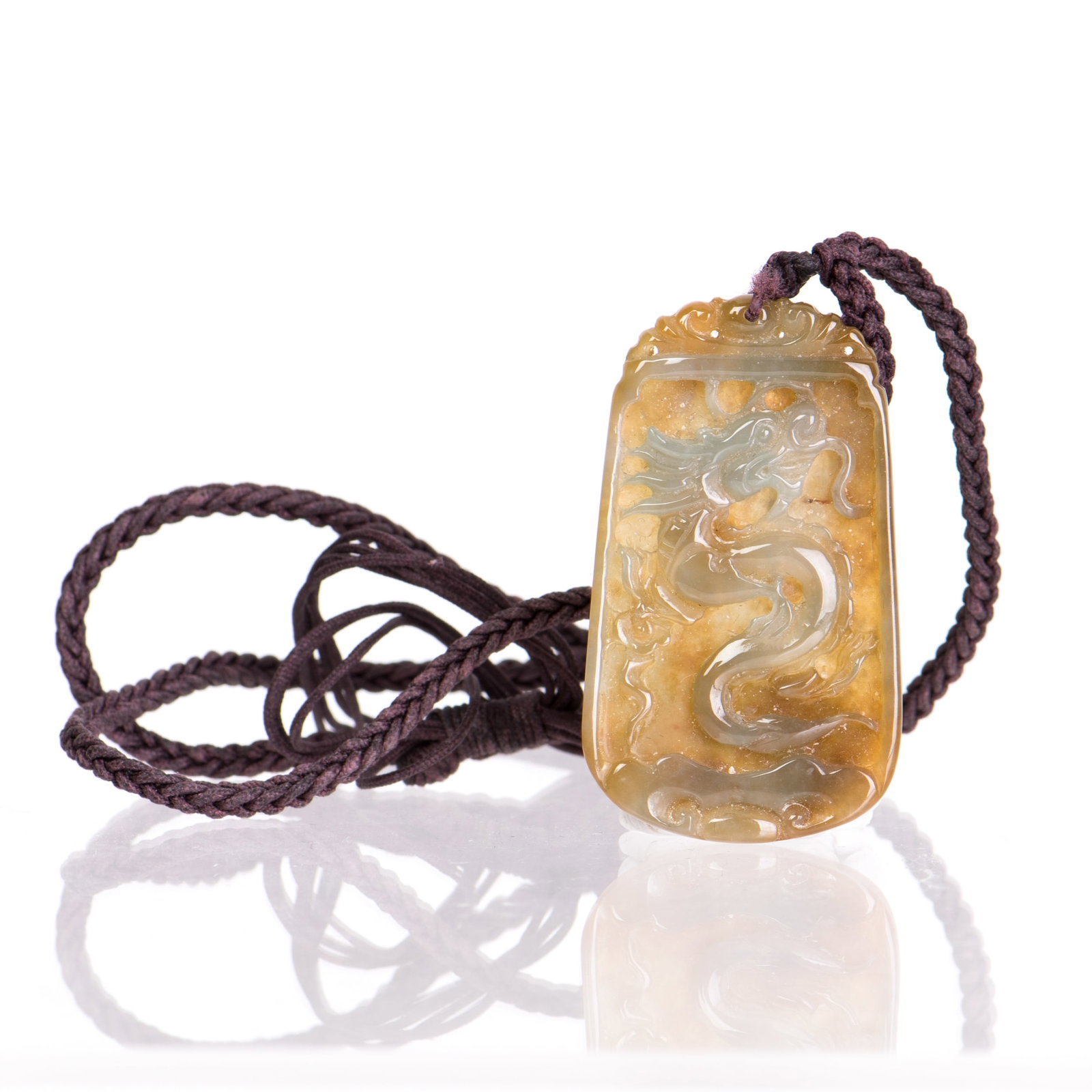 A JADE PENDANT WITH DRAGON MOTIF: A jade pendant with dragon motif. 2"h x 1.5"l (5.08 x 3.81 cm)