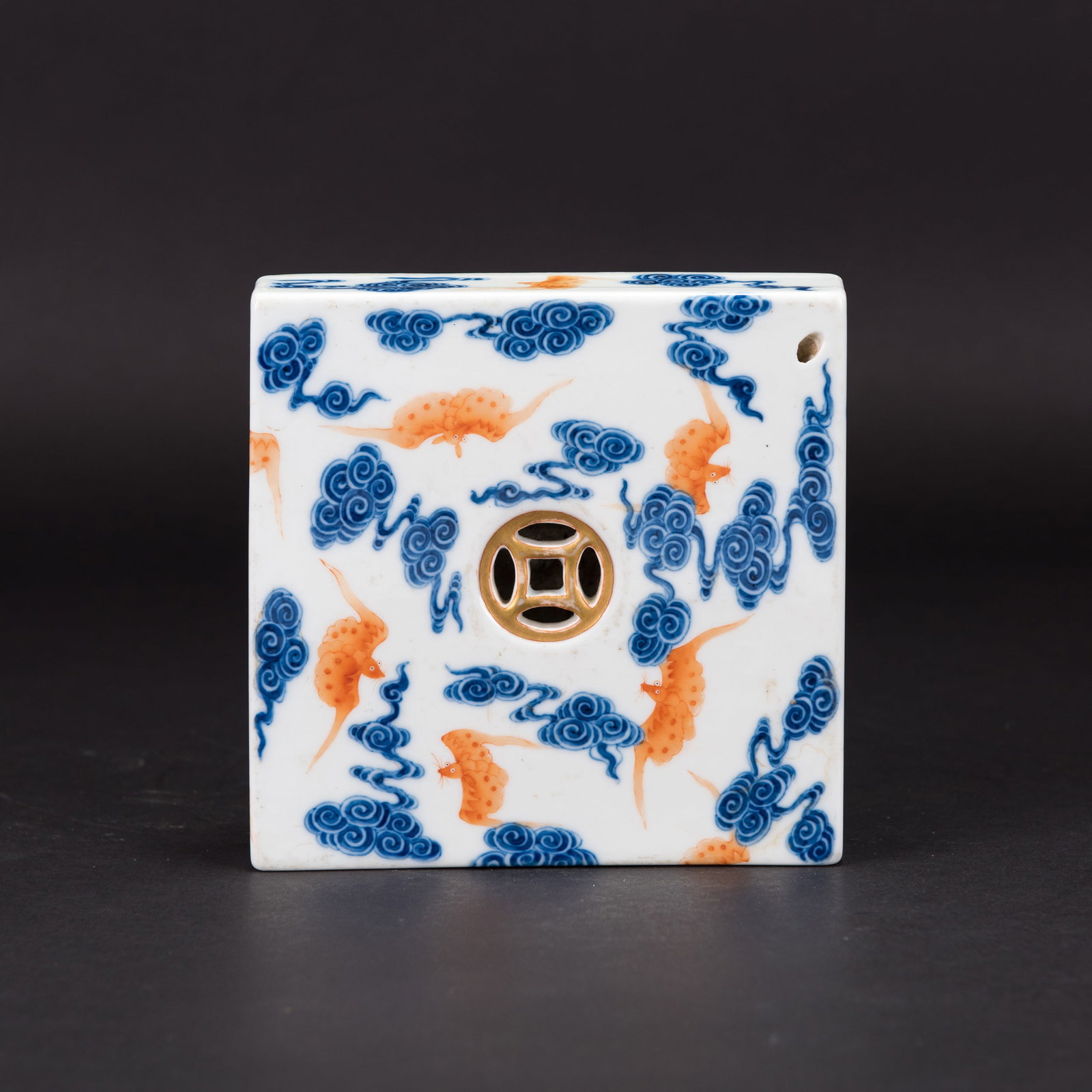 A BLUE-AND-WHITE AND IRON-RED 'BAT' PAPERWEIGHT, QIANLONG MARK: A blue-and-white and iron-red 'bat' paperweight, of square form and decorated with bats amidst ruyi-scroll clouds. The base bears a six-character "Da Qing Qian Long Nian Zhi" seal mark. H3.5 x 16 x 16