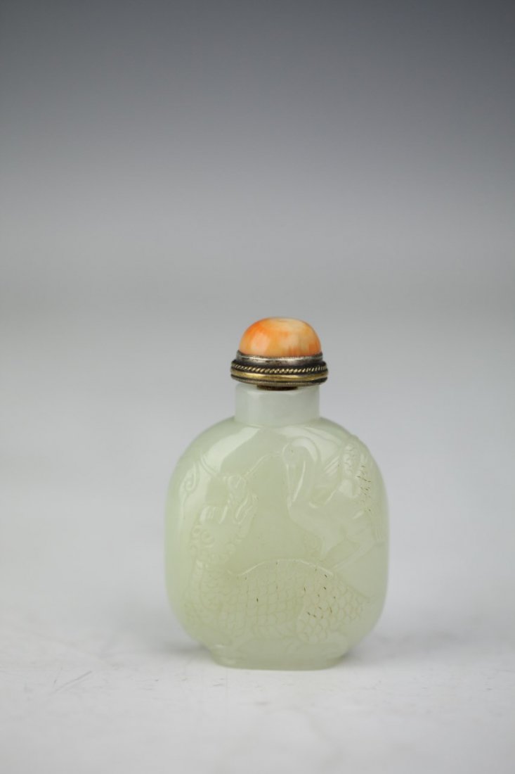 Chinese White Jade Snuff Bottle: Chinese White Jade snuff bottle with etchings of a swan and a mythical creature featuring a coral semi-precious cap with gold detailing. Height 3"