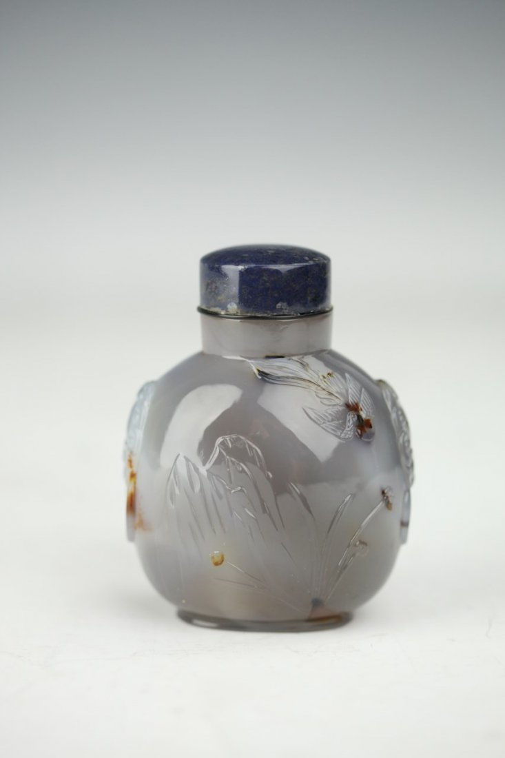 Agate Snuff Bottle: Agate snuff bottle of globular form featuring carving of nature landscape and semi-precious stone cap. Height 3.75"
