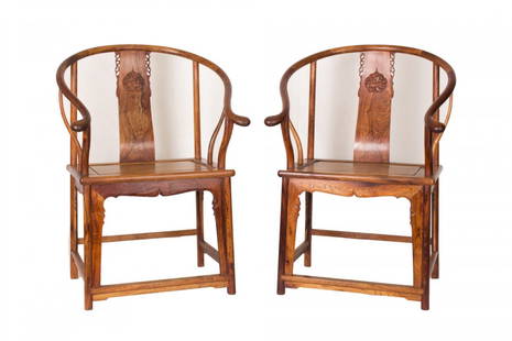 A pair of Huanghuali Chairs: A pair of Huanghualiwood Chairs, each of square shape, with delicate escutcheon splat back and exquisitely shaped curved arms, the seat supported by embellished front . Length 26.5" Width 18.25" Heig