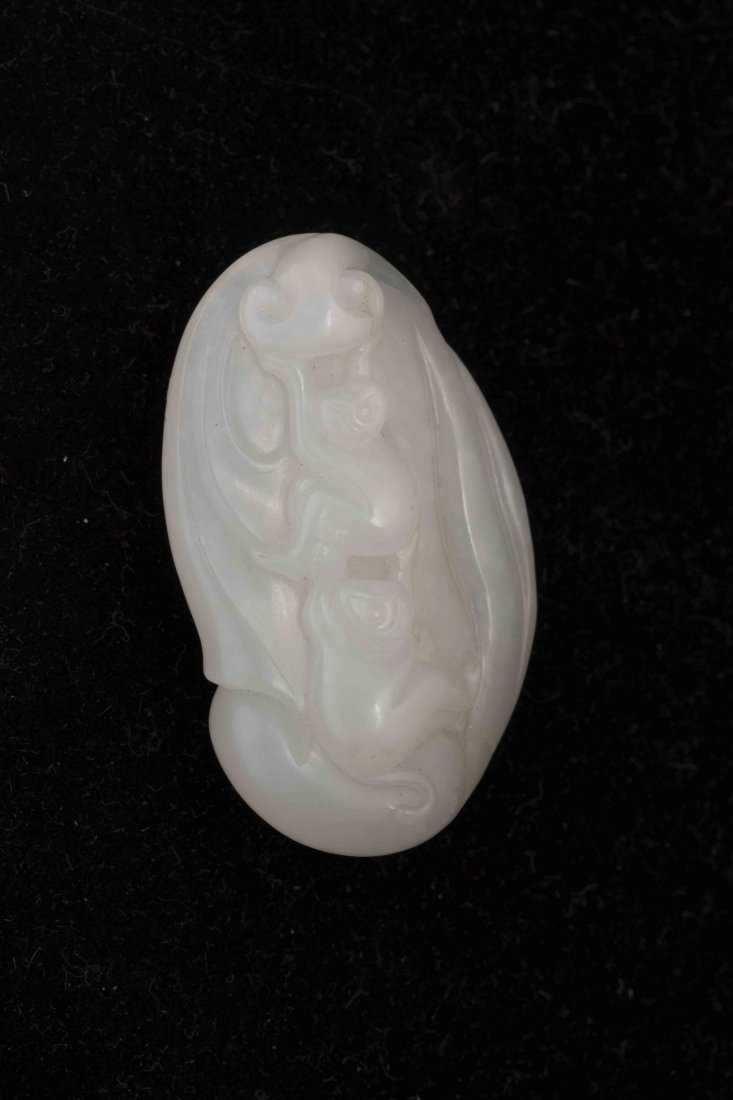 Chinese White Jade Pendant: Chinese white jade pendant, with the design of two monkeys reaching for the moon, of distorted ovoid form. Length 1.25" Width 0.5" Height 2"