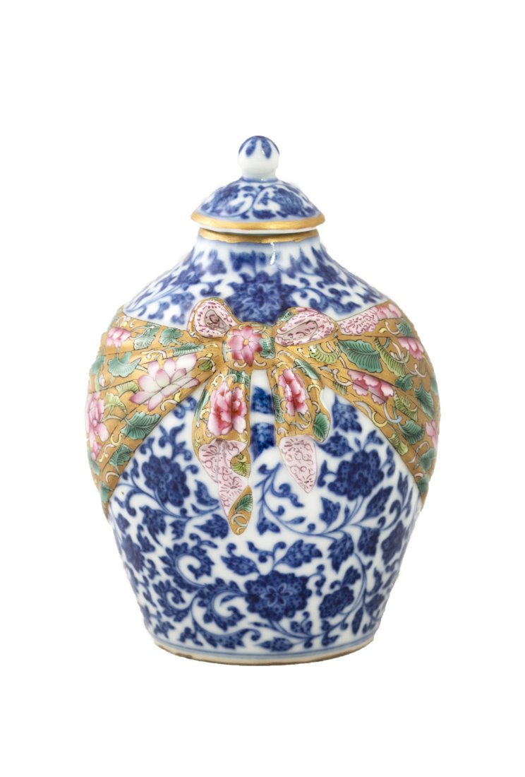 Chinese Porcelain Jar: Chinese white and blue enameled porcelain jar with cover, design with the body surrounded by colorful kerchief in golden tone, forming a bow at the front. Diameter 3" Height 4.75"