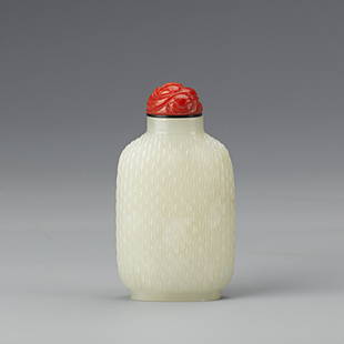 Chinese White Jade Snuff Bottle, 19th Century: Chinese White Jade Snuff Bottle, of rectangular form, carved with continuous wavy patterns all over the bottle, cap design with the red foo dog. Height 2.75"