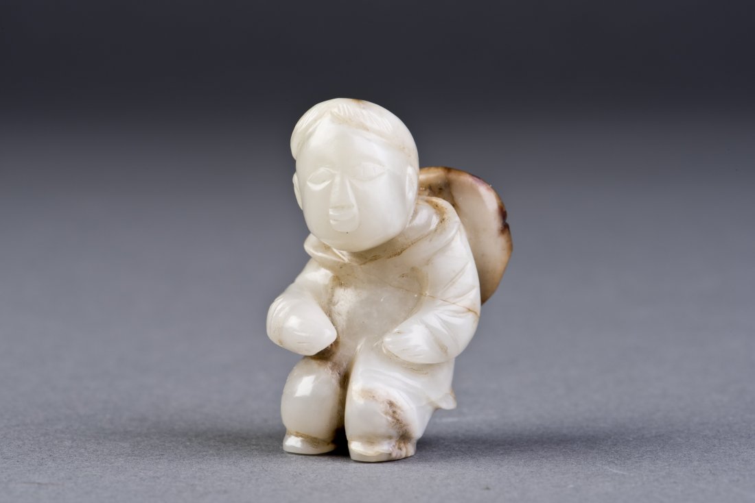 White Jade Figure: A finely carved white jade man carrying a straw hat on his back, with rich details and some russet suffusions throughout. Height 2'' Width 1''
