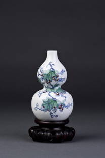 Chinese White Porcelain Double Gourd Vase: Doucai Porcelain Double Gourd Vase featuring colorful grapevine detailing resting atop a wooden carved lotus plinth base. Yongzheng seal imprint on base. Diameter 3'' Height 4.75''