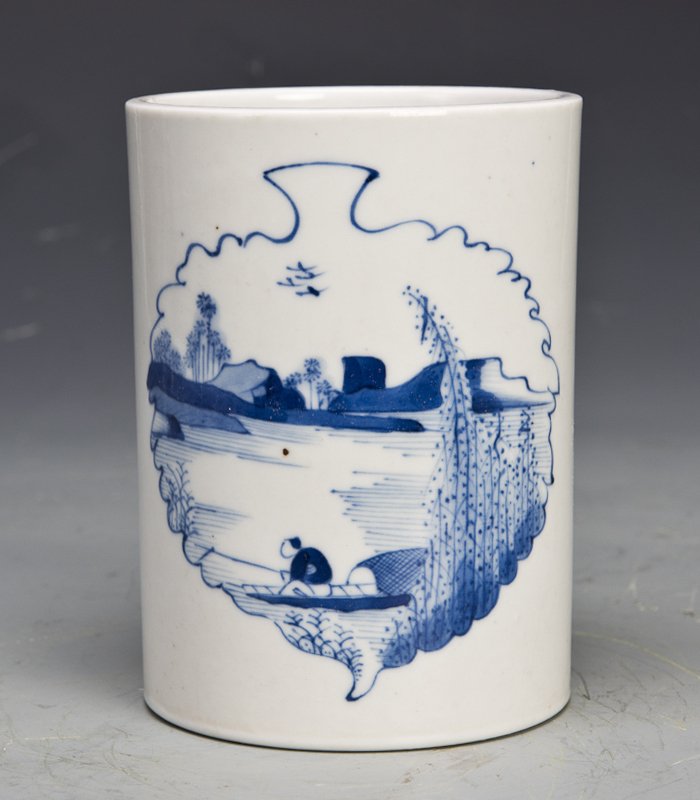 A CHINESE BLUE AND WHITE PORCELAIN BRUSH WASHER: A white and blue porcelain brush WASHER with a lake scenery encircled in a leaf outline on one side and landscape scenery on the other. Diameter 4" Height 5.25"