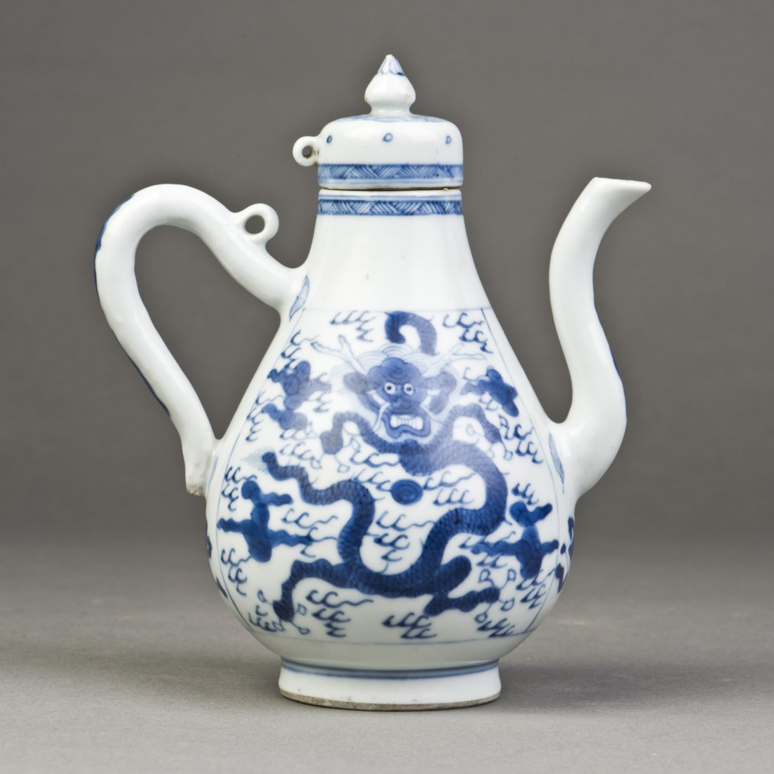 A BLUE AND WHITE PORCELAIN WINE VESSEL: A Chinese blue and white porcelain wine vessel featuring a front-facing dragon chasing flaming pearl amidst scrolling clouds, a four-character mark imprinted on the base. Height 6.25" Width 5.25
