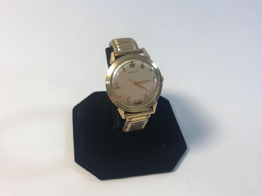FREEMASON WRIST WATCH ~ HAMILTON W/OFF-WHITE FACE FT.: FREEMASON WRIST WATCH ~ HAMILTON W/OFF-WHITE FACE FT. TAPERED GOLD TONE HANDSAND GOLD TONE MASONIC EMBLEM INDICATORS. SPEIDEL STRETCH BAND. 10KT GOLD-FILLEDCASE.