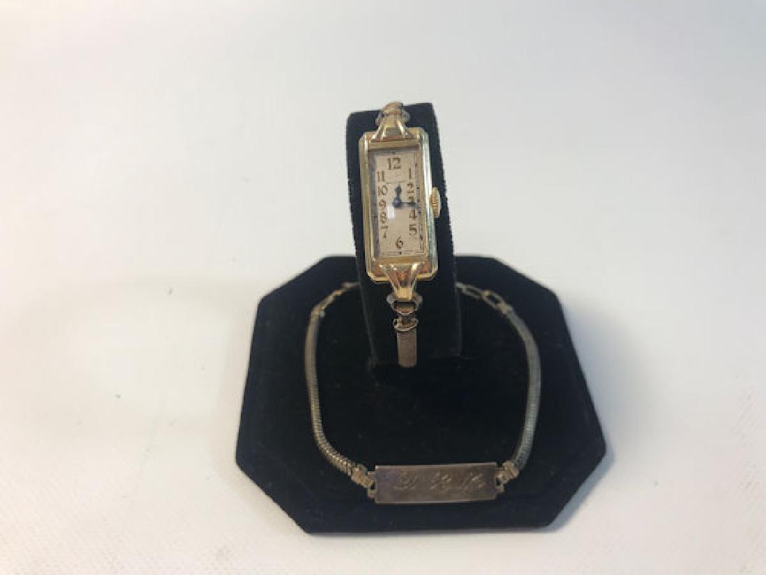 GOLD-FILLED WATCH AND NAME BRACELET ~ 7" BRACELET: GOLD-FILLED WATCH AND NAME BRACELET ~ 7" BRACELET W/FOLDOVER CLASP CLOSUREMONOGRAMMED "DLM". VINTAGE WATCH FROM WALTHAM W/FOLDING CLASP, OFF-WHITEFACE, AND LIGHTLY EMBOSSED CASE DETAILING ON SIDES.