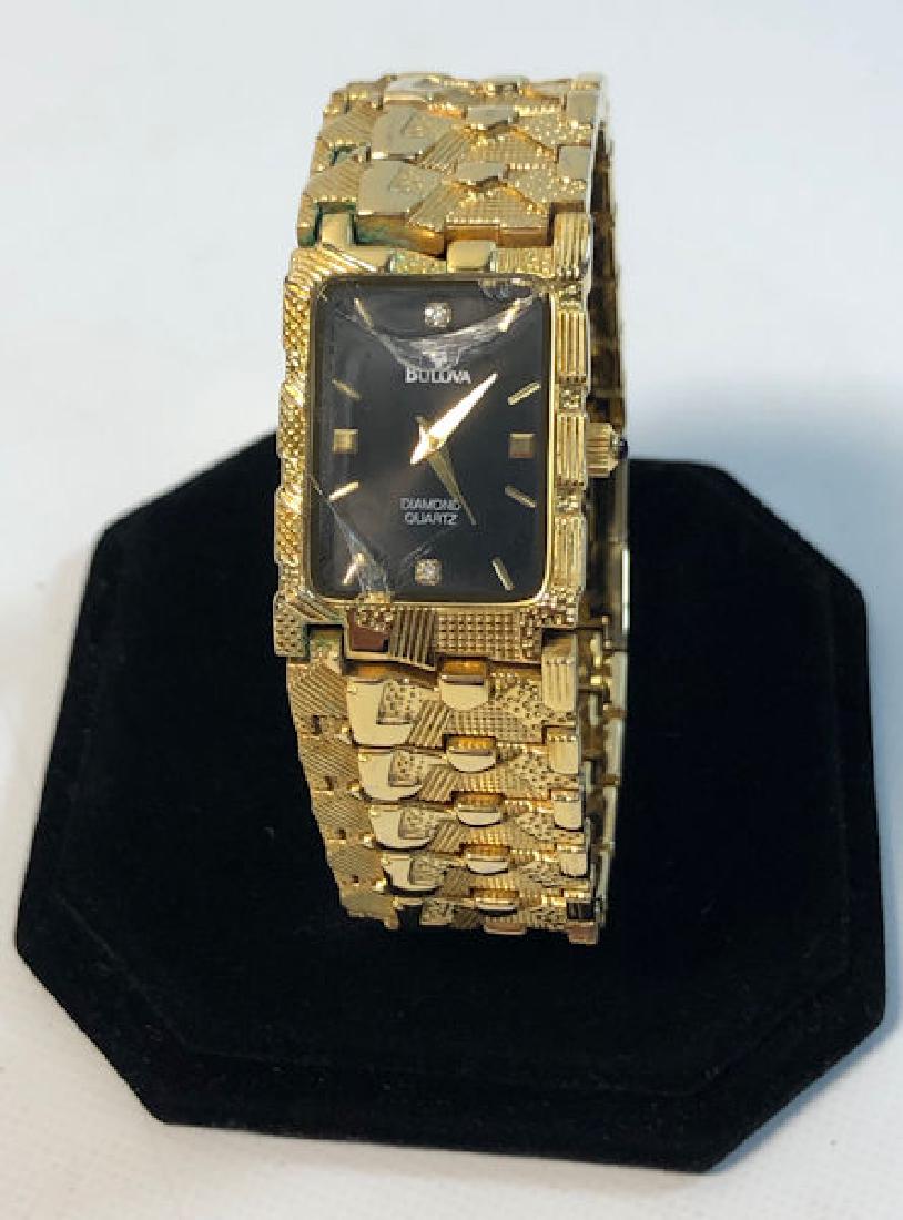 GOLD TONE BULOVA WRIST WATCH ~ BROKEN CRYSTAL. BLACK: GOLD TONE BULOVA WRIST WATCH ~ BROKEN CRYSTAL. BLACK FACE W/INSET CLEARSTONES. STAMPED 18KT (DOES NOT TEST). SWISS MOVEMENT. NUMBERED #2020.