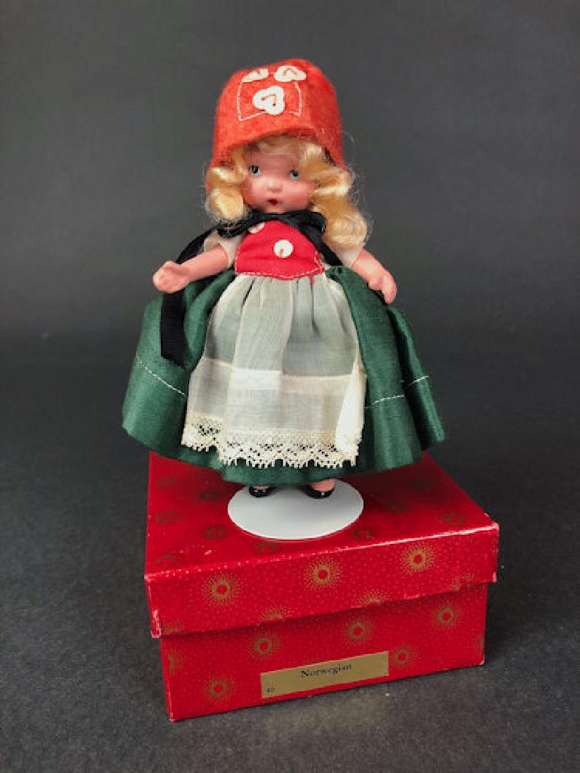 5¼" JUDY ANN STORYBOOK DOLL IN ORIGINAL COSTUME: 5¼" JUDY ANN STORYBOOK DOLL IN ORIGINAL COSTUME AND RED SUNBURST BOX. "JUDY ANN USA" MARK ON JOINTED PT BISQUE BODY, MOLDED SOCKS AND GOLD FOIL LABEL ON BOX "NORWEGIAN" #40.