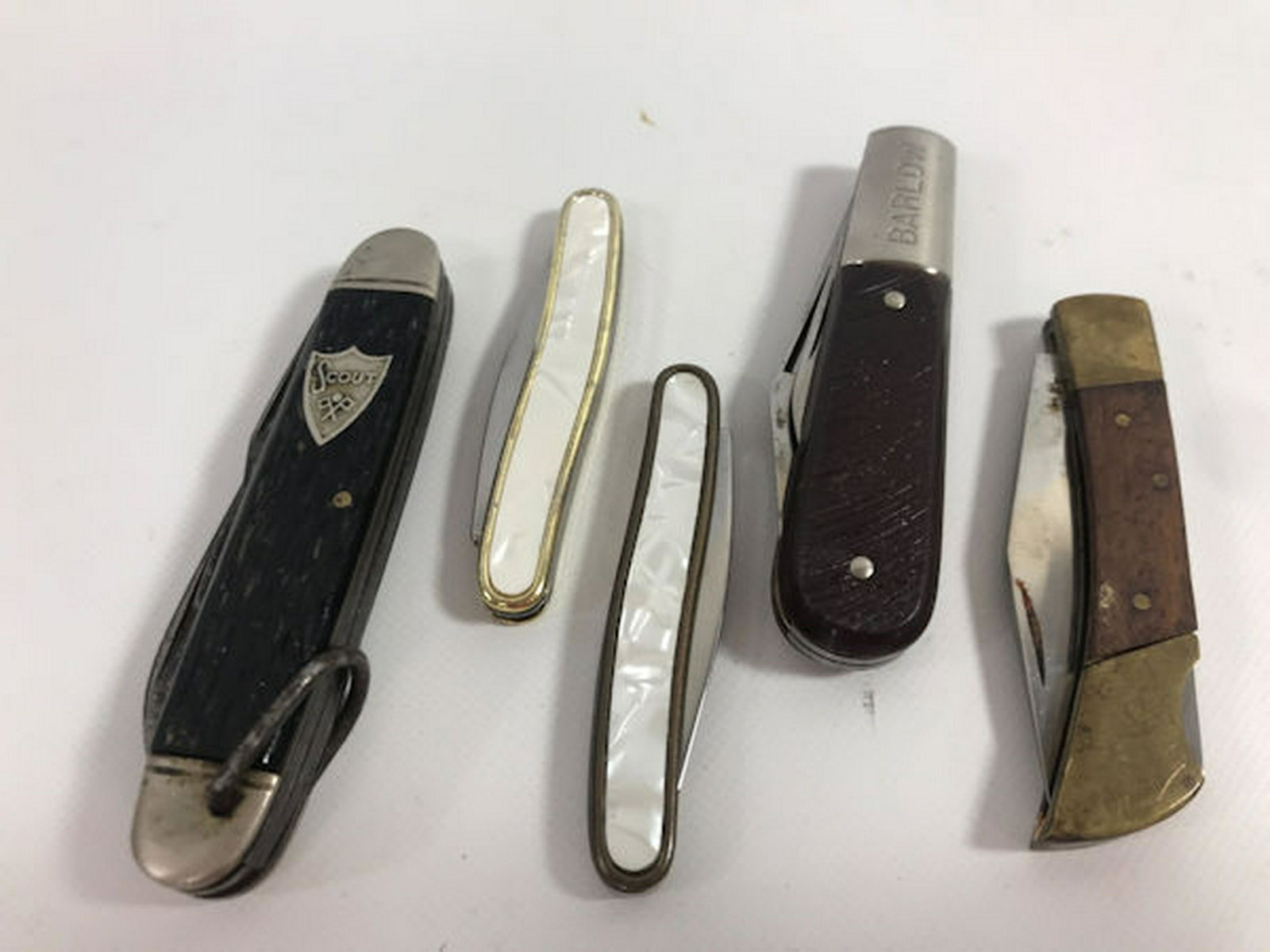 FIVE FOLDING KNIVES: FIVE FOLDING KNIVES ~ STYLES FROM BARLOW, CAMILLUS, AND COLONIAL. DESIGNS INCLUDING CAMILLUS SCOUT KNIFE AND TWO W/WHITE NACRE SCALES. BLADES INCLUDING: CLIP POINT, SPEAR POINT, PEN KNIVES, AND DROP P