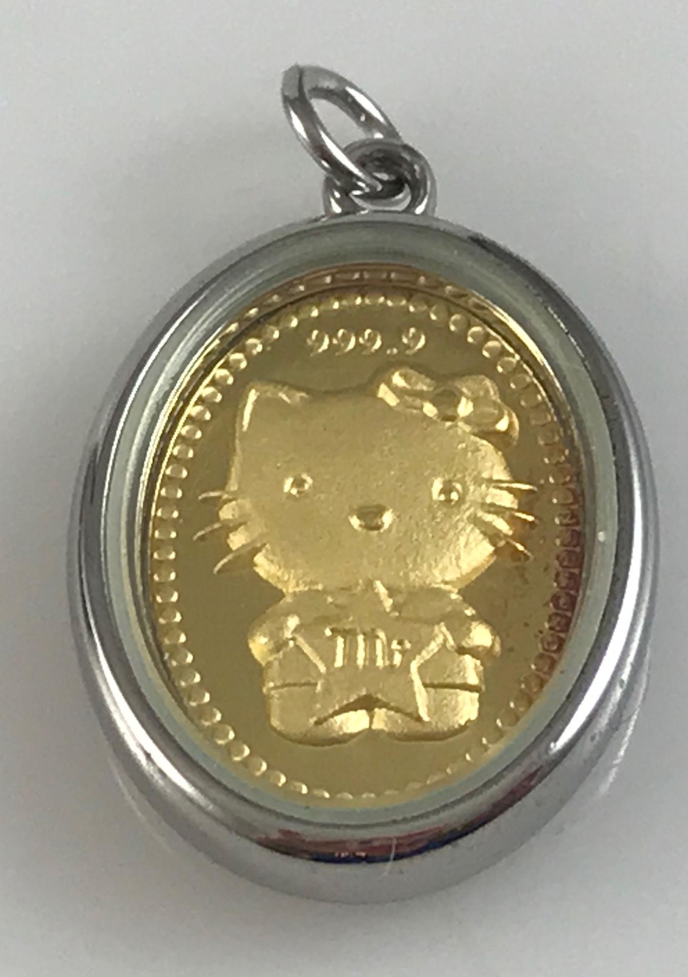 FINE GOLD HELLO KITTY PENDANT: FINE GOLD HELLO KITTY PENDANT ~ ENCASED IN APPROX. 1" OVAL SHAPED SILVER TONE BEZEL (3.7 GRAMS TW)-WEIGHT IN CASE, STAMPED 999.9