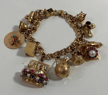 GOLD CHARM BRACELET: GOLD CHARM BRACELET ~ 14KT YELLOW GOLD CHARM BRACELET W/ GOLD CHARMS, 7" IN LENGTH W/ UNIQUE CHARMS INCLUDING GOLD TELEPHONE W/ PINK AND BLUE SAPPHIRE DIAL W/ PEARL ACCENT, DIAL TURNS, GOLD PLAYING CA