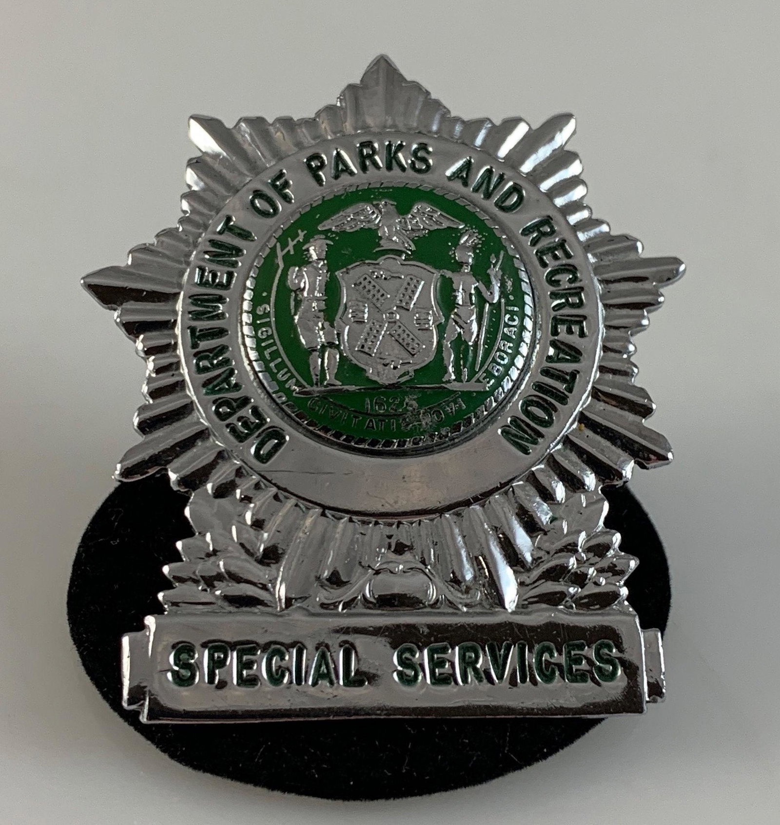 PARKS AND RECREATION BADGE: PARKS AND RECREATION BADGE ~ 2" X 1.75" IN SIZE. SILVER TONE METAL STAMPED "67" ON REVERSE. "SPECIAL SERVICES" BADGE.