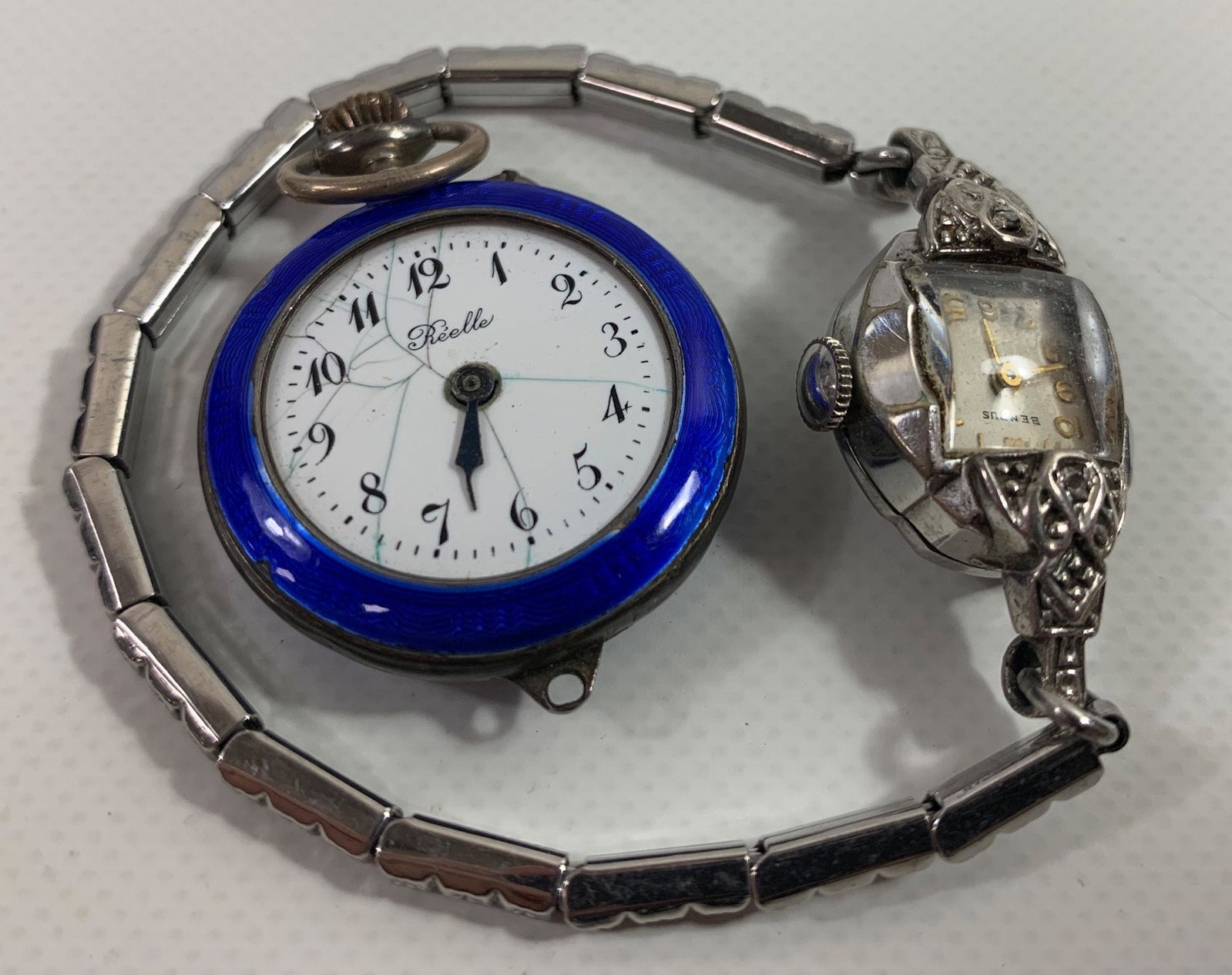 TWO WATCHES: TWO WATCHES ~ LOT INCLUDES ONE SILVER TONE LADIES WRIST WATCH FROM BENRUS, GOLD TONE NUMBERS & INDICATORS, SILVER TONE STRETCH BAND W/ SMALL MELEE DIAMOND ACCENTS AND ONE APPROX 1.125" ROYAL BLUE ENAM