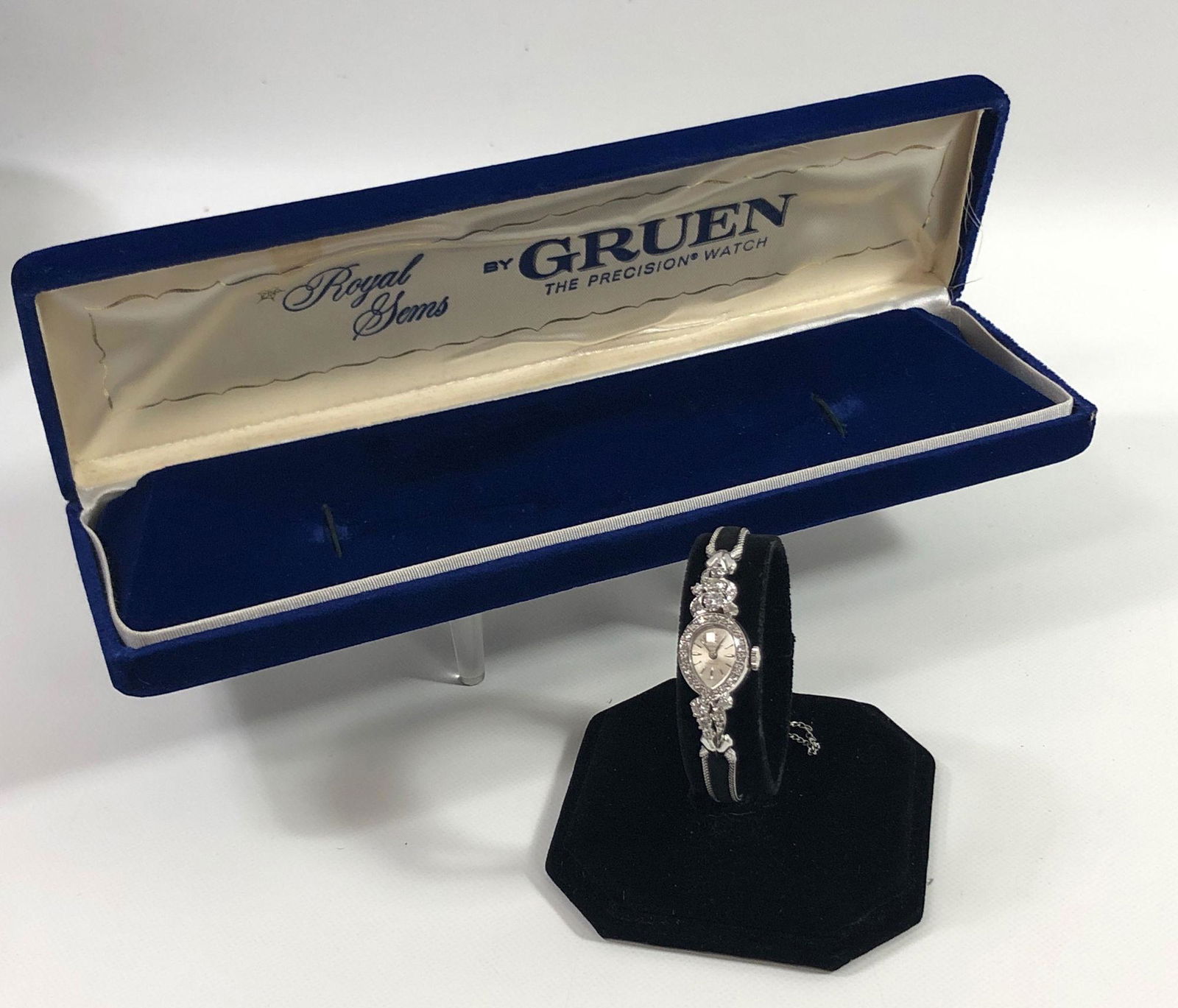 14KT WHITE GOLD VINTAGE LADIES WATCH: 14KT WHITE GOLD VINTAGE LADIES WATCH ~ MADE BY GRUEN SINGLE CUT DIAMOND HALO SURROUNDING TEAR DROP SHAPE BEZEL AND ROUND DIAMONDS AT 6 & 12 O'CLOCK (APPROX. 0.66CT TDW) BLACK FELT AND MESH BAND 6.75"