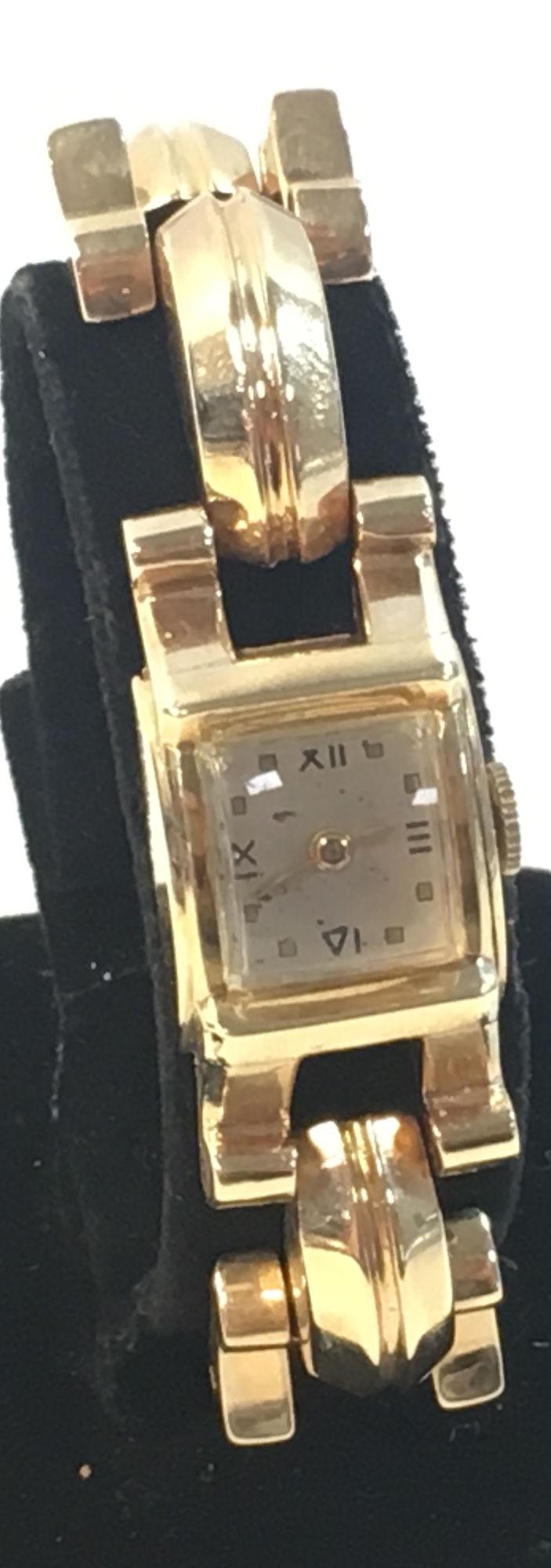 14KT GOLD WRIST WATCH: 14KT GOLD WRIST WATCH ~ GOLD CASE AND BAND (YELLOW GOLD). WORN OFF-WHITE FACE. STEM SET. WINDS/SETS/TICKS. HIGH POLISH FINISH. CLAMP STYLE CLASP. TAPERED GOLD TONE HANDS. 7" IN LENGTH. 50.2 GRAMS TW.