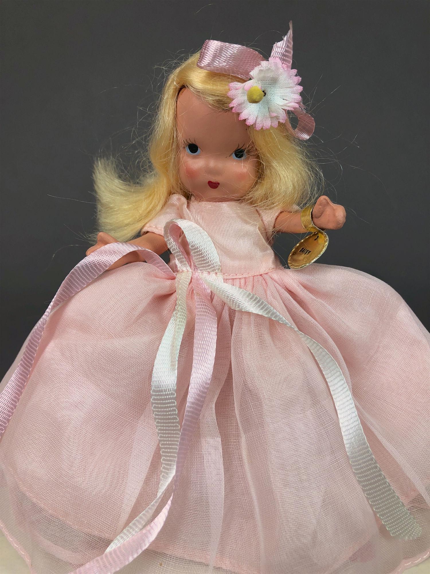 5" STORYBOOK DOLL IN ORIGINAL COSTUME. "STORYBOOK DOLL: 5" STORYBOOK DOLL IN ORIGINAL COSTUME. "STORYBOOK DOLL USA" MARK ON JOINTED PT BISQUE BODY, GOLD FOIL WRIST TAG, "STORYBOOK DOLLS" "DAISY" AND PAINTED BLACK SLIPPERS. COMES WITH WHITE BOX/PINK DOTS AN