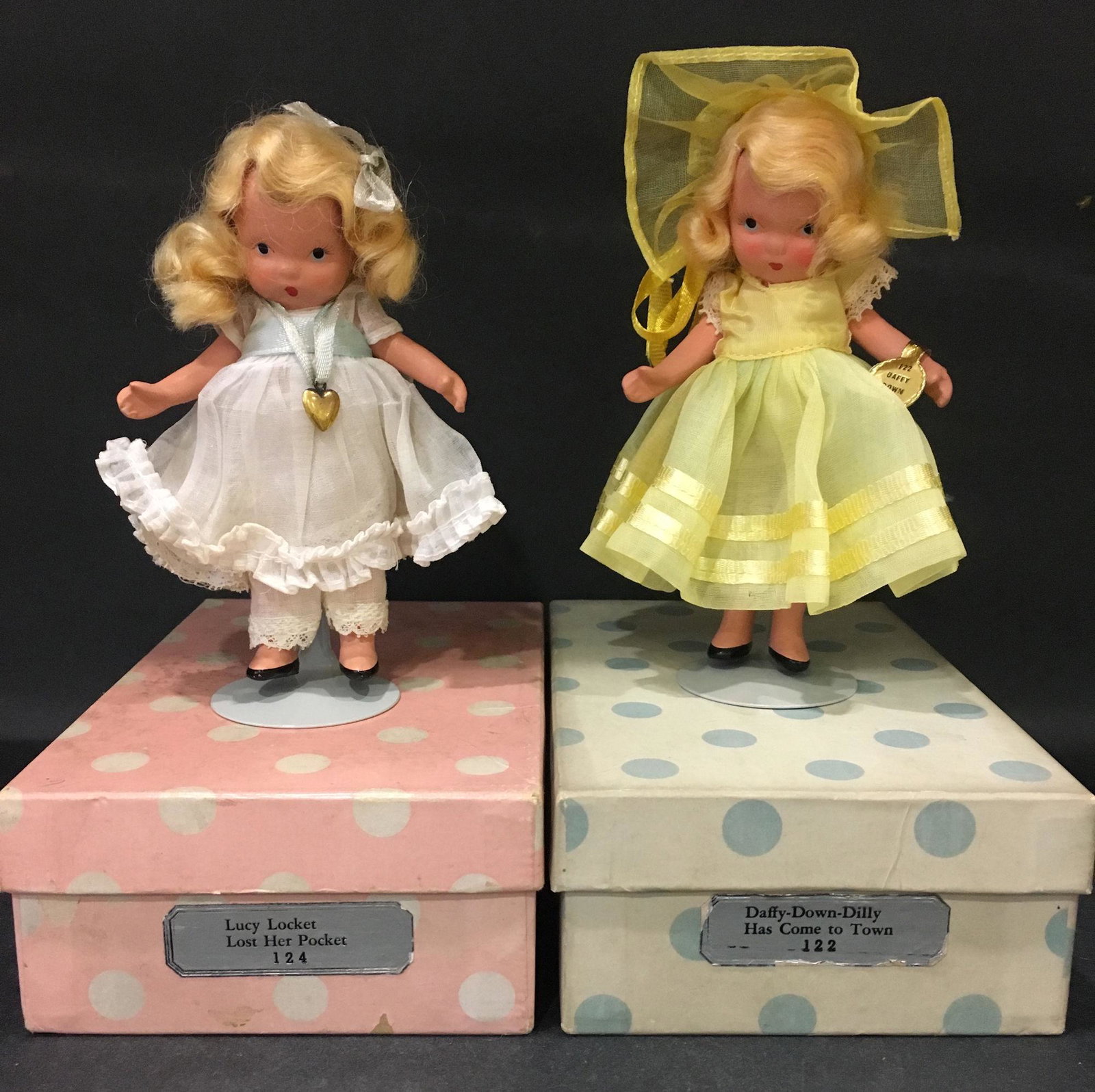 (2) 5½" STORYBOOK DOLLS IN ORIGINAL COSTUMES.: (2) 5½" STORYBOOK DOLLS IN ORIGINAL COSTUMES. 1.) "LUCY LOCKET LOST HER POCKET" #124 WITH "STORY BOOK DOLL USA 11" MARK ON JOINTED PT BISQUE BODY WITH MOLDED SOCKS. COMES IN PINK BOX/WHITE DOTS