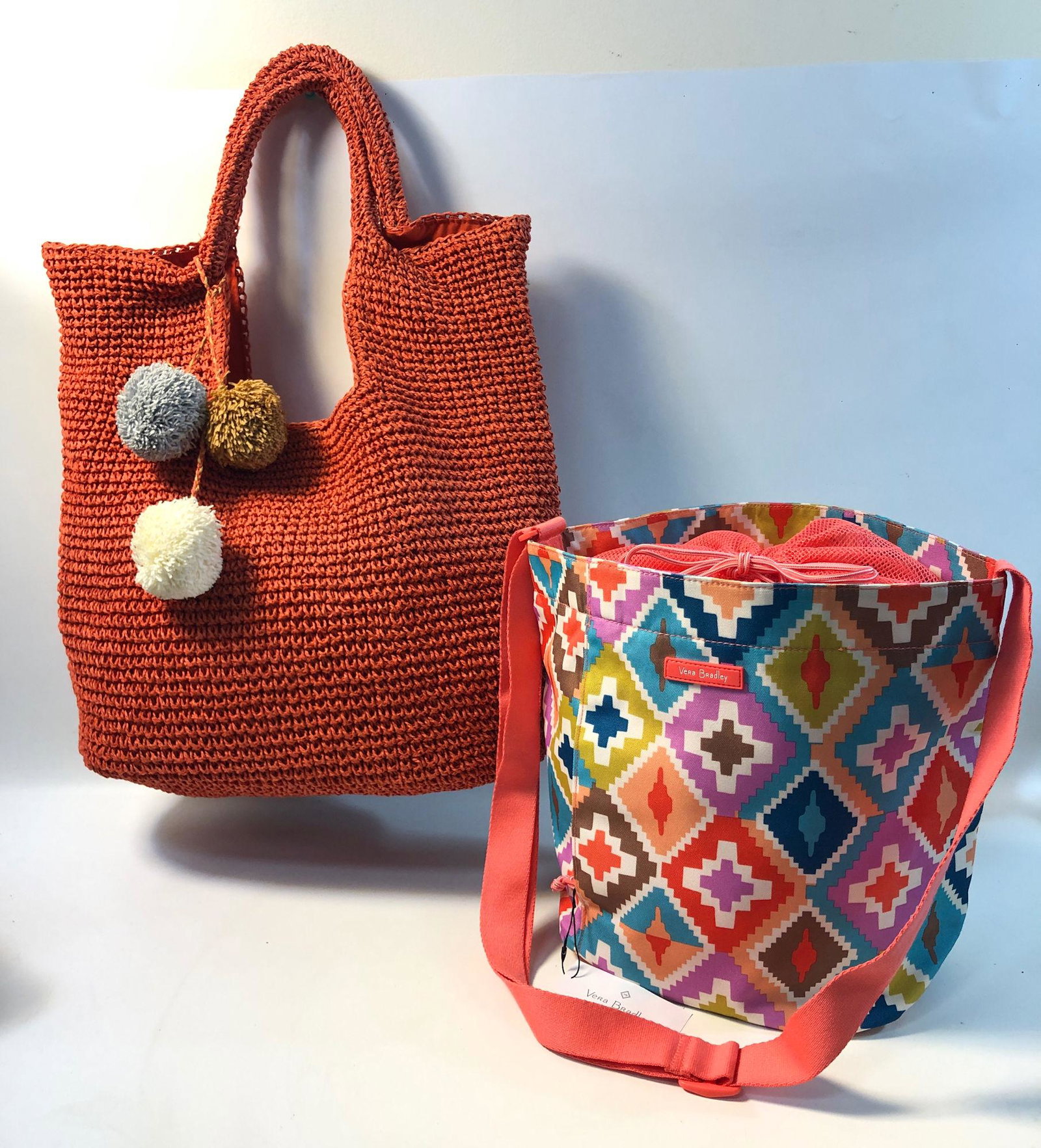 TWO DESIGNER TOTE BAGS: TWO DESIGNER TOTE BAGS ~ LOT INCLUDES, DRAWSTRING TRAVEL TOTE FROM VERA BRADLEY, MULTICOLORED DESIGN-NEW WITH TAG, ADJUSTABLE STRAP, AND ONE BURNT ORANGE SHOULDER BAG FROM STREET LEVEL WITH THREE POM 