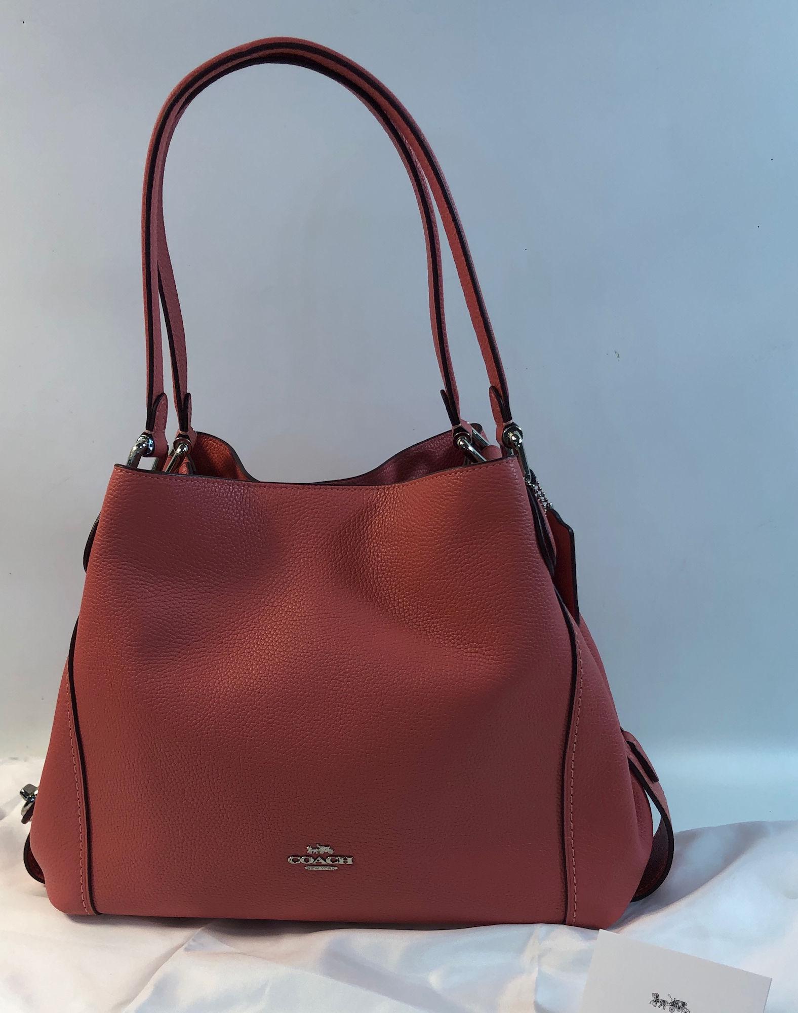 COACH EDIE SHOULDER BAG: COACH EDIE SHOULDER BAG ~ PEBBLED PINK LEATHER, LIKE NEW CONDITION WITH CARE CARD AND TRAVEL BAG INCLUDED, THREE MAIN COMPARTMENTS, CENTER COMPARTMENT FEATURES ZIPPER LOCK, ADDITIONAL COMPARTMENTS FEA