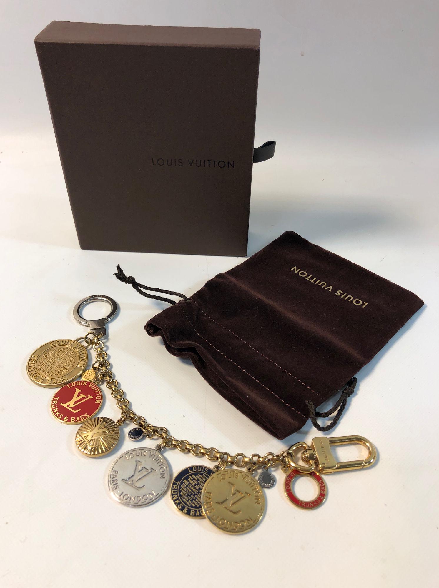 LOUIS VUITTON PURSE CHARM: LOUIS VUITTON PURSE CHARM ~ TRUNKS AND BAGS MULTI TONE DUEL ENDED CHARM, APPROX. 9.5" IN LENGTH, ITALIAN MADE, MINOR SCRATCHING AND DISCOLORATION FROM USE, BRANDED BOX, CLEANING CLOTH AND TRAVEL POUCH