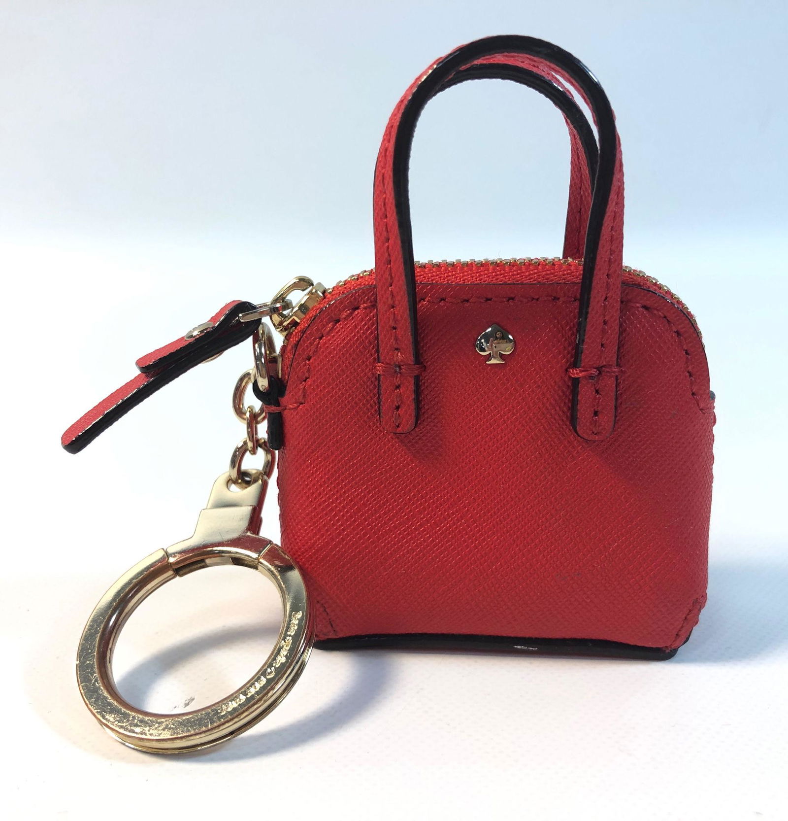 KATE SPADE NEW YORK PURSE/KEYCHAIN: KATE SPADE NEW YORK PURSE/KEYCHAIN ~ SMALL 3.5" X 2.5" ACCESSORY. TEXTURED RED LEATHER W/BRANDED GOLD TONE KEY RING/CHAIN.