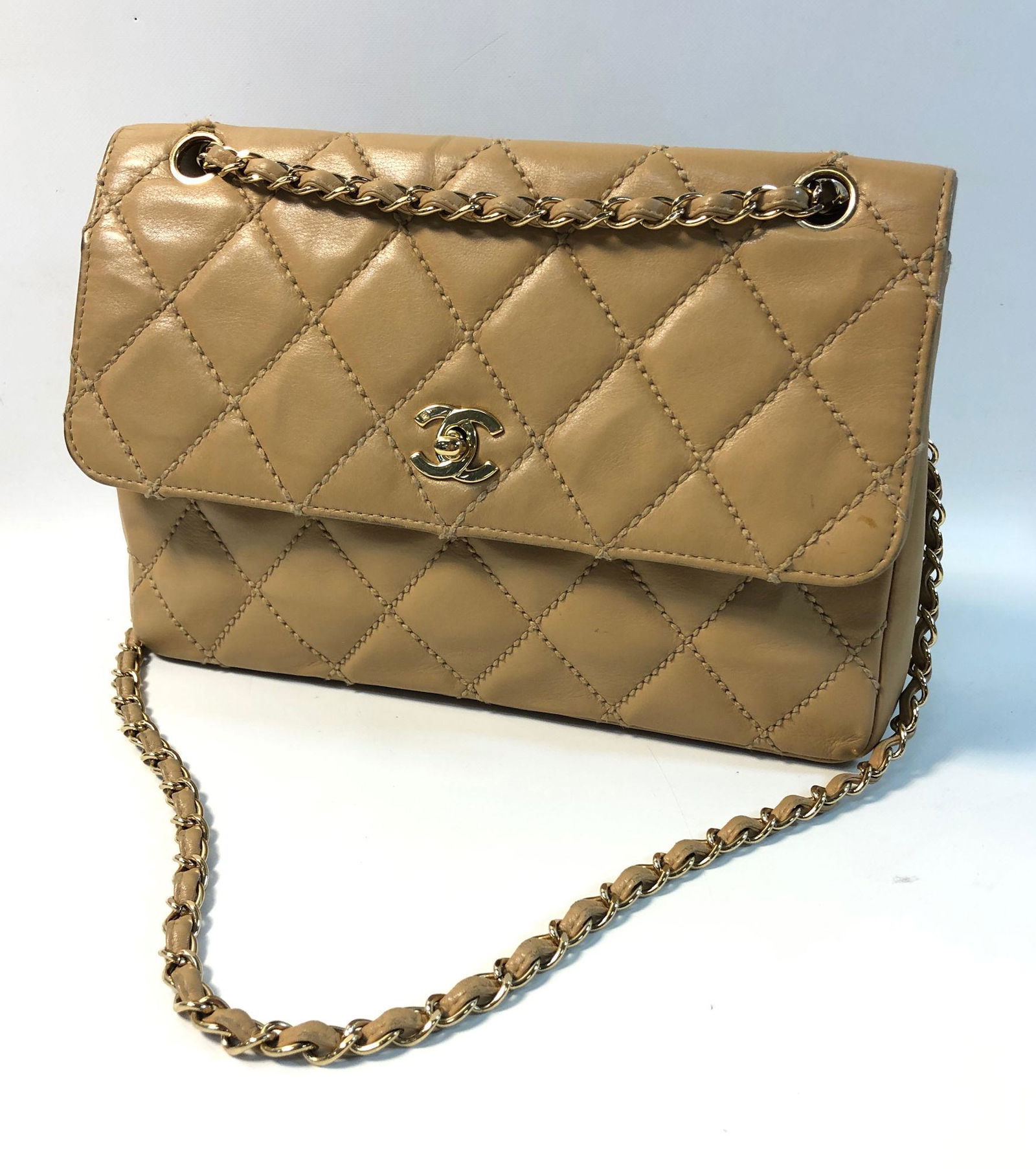 VINTAGE CHANEL HANDBAG: VINTAGE CHANEL HANDBAG ~ QUILTED TAN LEATHER, GOLD TONE HARDWARE, THREADED CROSSBODY CHAIN/WOVEN LEATHER STRAP, FOLDOVER TOGGLE CLASP CLOSURE, EXTERIOR CONDITION-BAG HAS BEEN WELL WORN AND SHOWS DISCO
