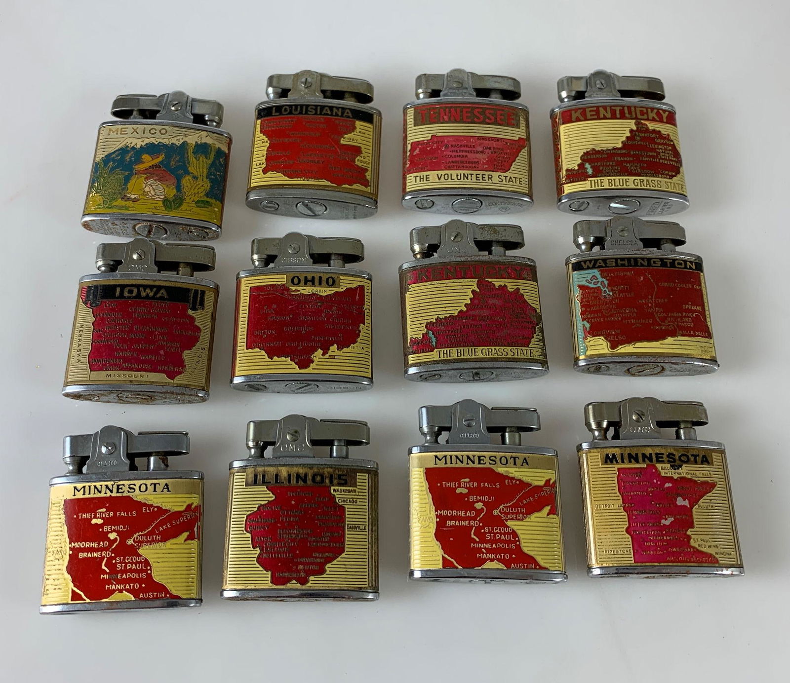 TWELVE VINTAGE STATE TRAVEL LIGHTERS LIGHTERS: TWELVE VINTAGE STATE TRAVEL LIGHTERS LIGHTERS ~ MOST BLUE W/PINSTRIPE DESIGN (+ ONE MEXICO). STYLES MARKED CONTINENTAL, FIREFLY, CHELSEA, GIBSON, STARFIRE, AND CHARCO. STATES LIGHTERS W/STATE BIRD, FL
