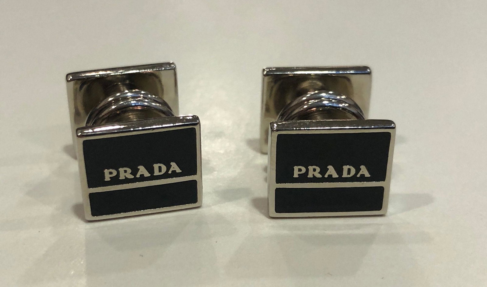 PRADA CUFFLINKS: PRADA CUFFLINKS ~ NEW OLD STOCK IN BOX. BLACK/SILVER DESIGN (BRANDED). ITALIAN MADE. SNAP CLOSURES.