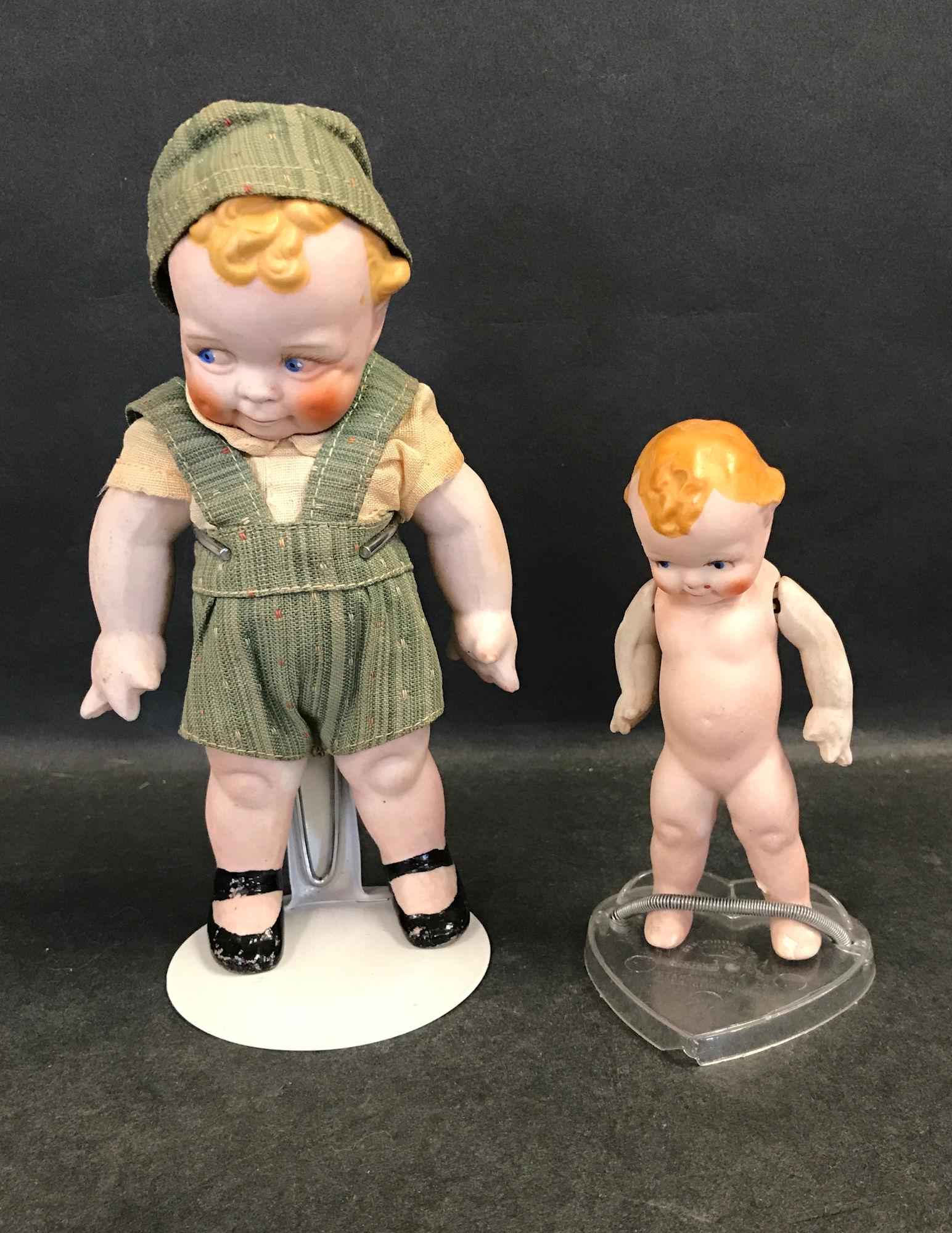 (2) ALL BISQUE SCOOTLES. 6 ¾" WITH ONE PIECE: (2) ALL BISQUE SCOOTLES. 6 ¾" WITH ONE PIECE HEAD, TORSO AND LEGS, STRING JOINTED ARMS WITH STARFISH HANDS, MOLDED AND PAINTED CURLY HAIR, INTAGLIO SIDE GLANCING EYES, CLOSED MOUTH, PAINTED ONE