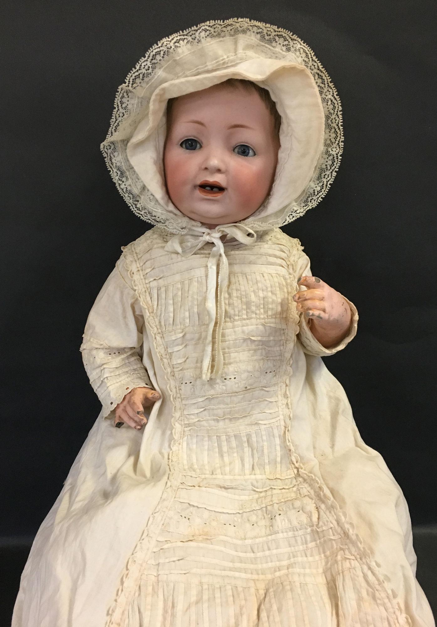 19" J.D.K. 211 BISQUE SOCKET HEAD CHARACTER BABY.: 19" J.D.K. 211 BISQUE SOCKET HEAD CHARACTER BABY. ORIGINAL MOHAIR WIG AND PLASTER PATE, GLASS SLEEP EYES AND OPEN MOUTH WITH TWO TEETH. COMPOSITION FIVE-PIECE BABY BODY WITH ORIGINAL FINISH WEARING AN