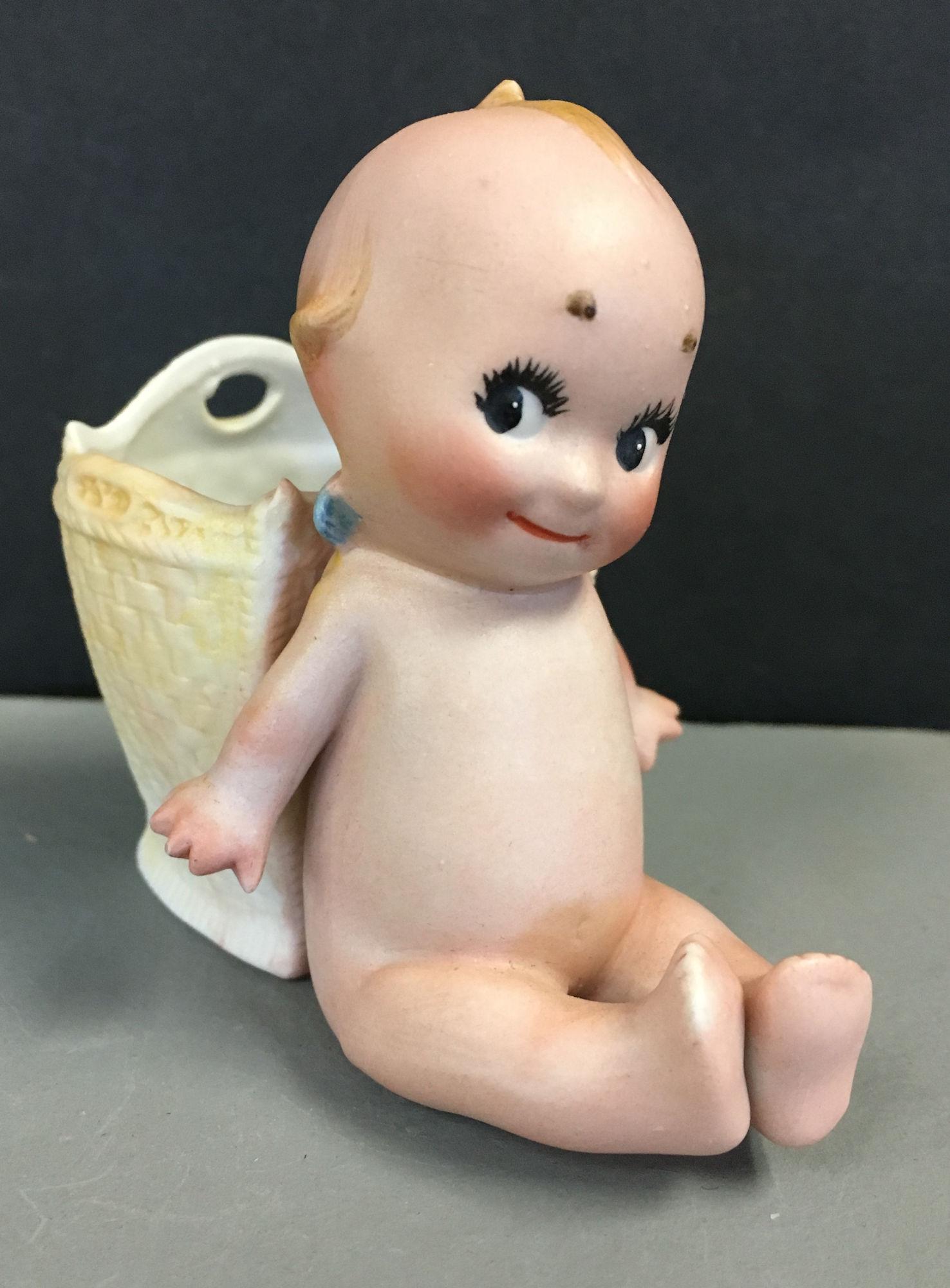 SEATED KEWPIE LEANING AGAINST A WOVEN BASKET. 3 ½ (1 of 5)