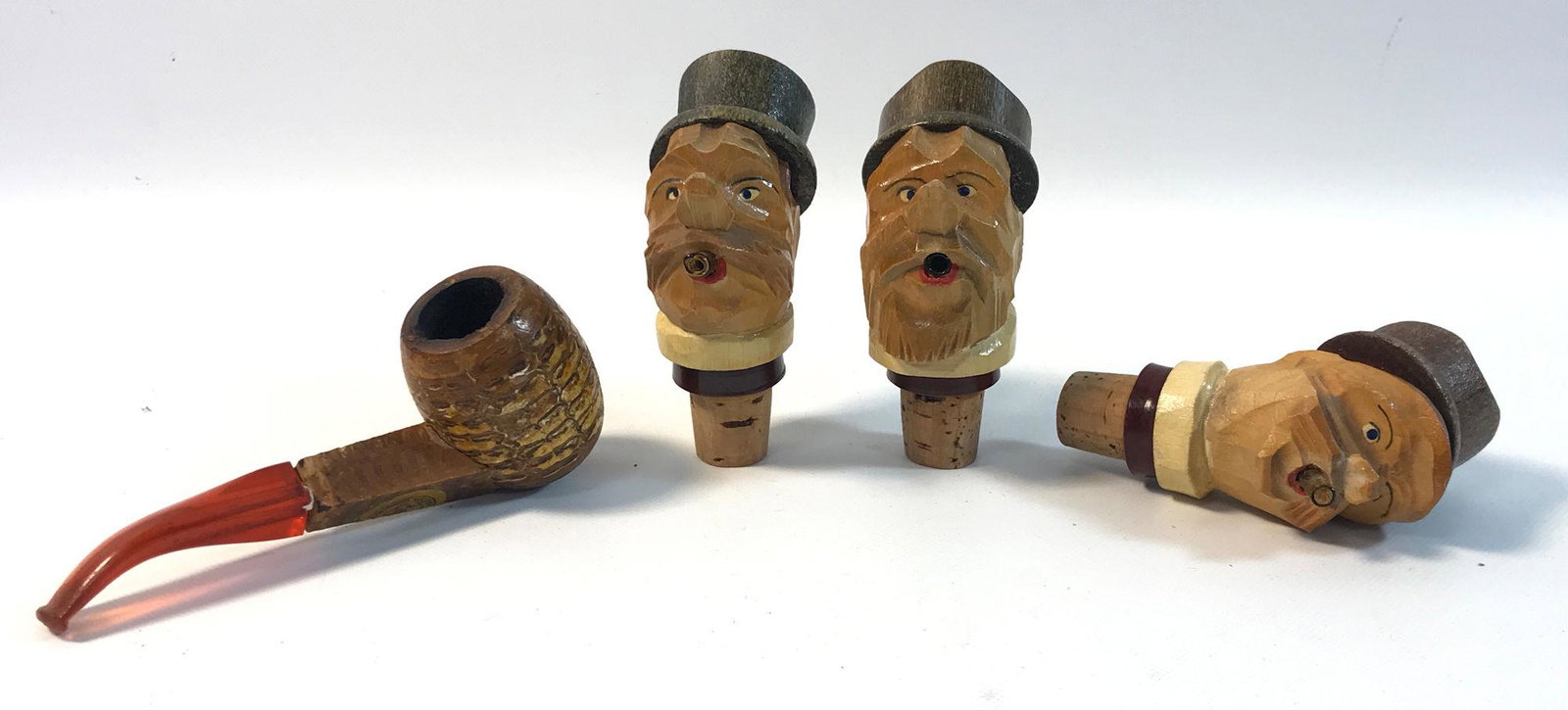 VINTAGE ACCESSORIES: VINTAGE ACCESSORIES ~ LOT INCLUDES THREE HAND CARVED WINE STOPPERS THAT FEATURE GENTLEMEN SMOKING CIGARS, CIGARS FUNCTION AS AERATOR AND ONE CORN COB PIPE FROM MISSOURI MEERSCHAUM CO.
