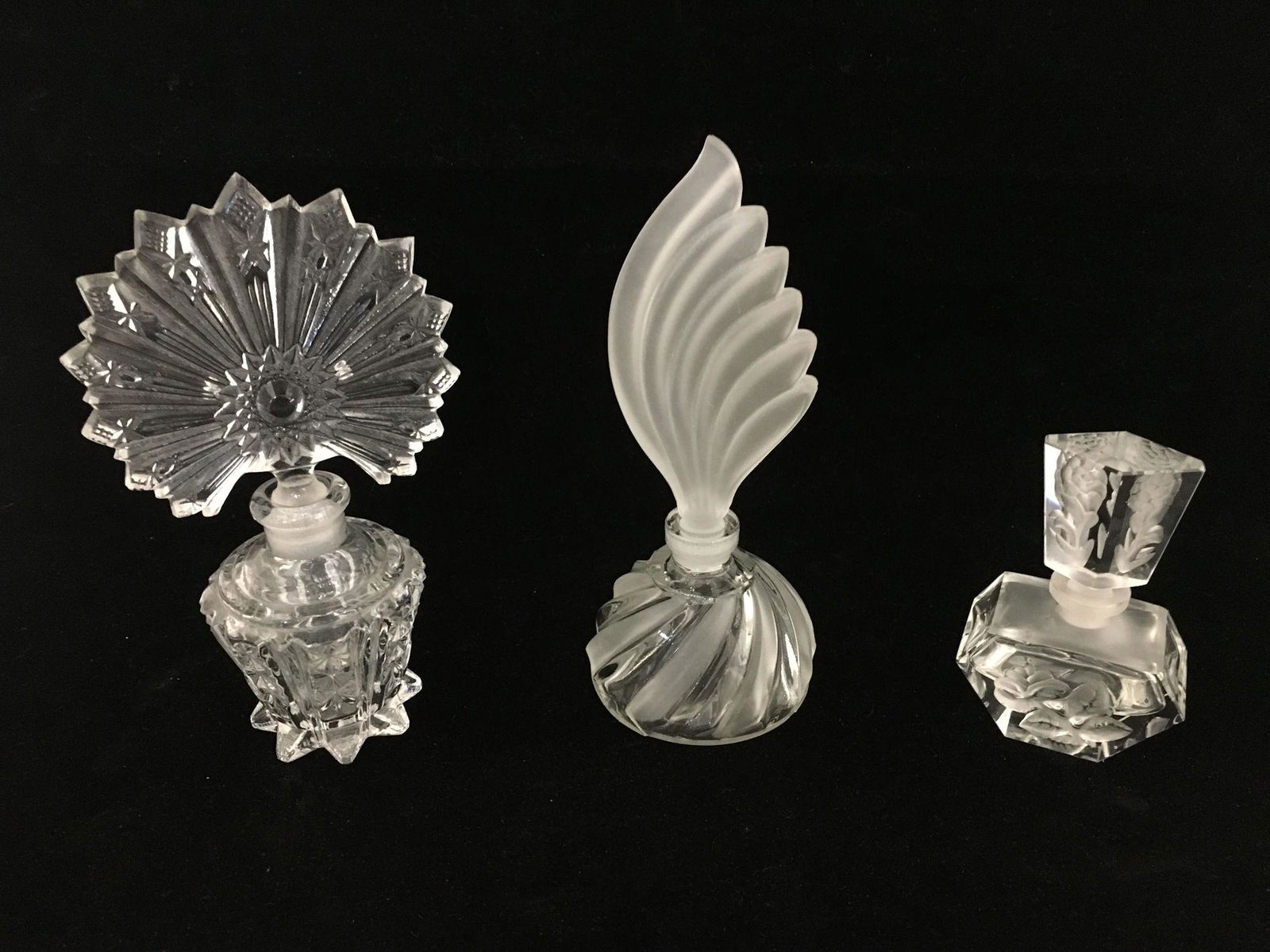 THREE VINTAGE GLASS/CRYSTAL PERFUME BOTTLES: THREE VINTAGE GLASS/CRYSTAL PERFUME BOTTLES ~ NO CONTENTS. FROSTED AND ETCHED CRYSTAL BOTTLES. 4" - 7.5" IN HEIGHT. FEATHER, PEACOCK, AND FLORAL MOTIFS. NO MARKINGS ON BOTTOM. GOOD CONDITION OVERALL.