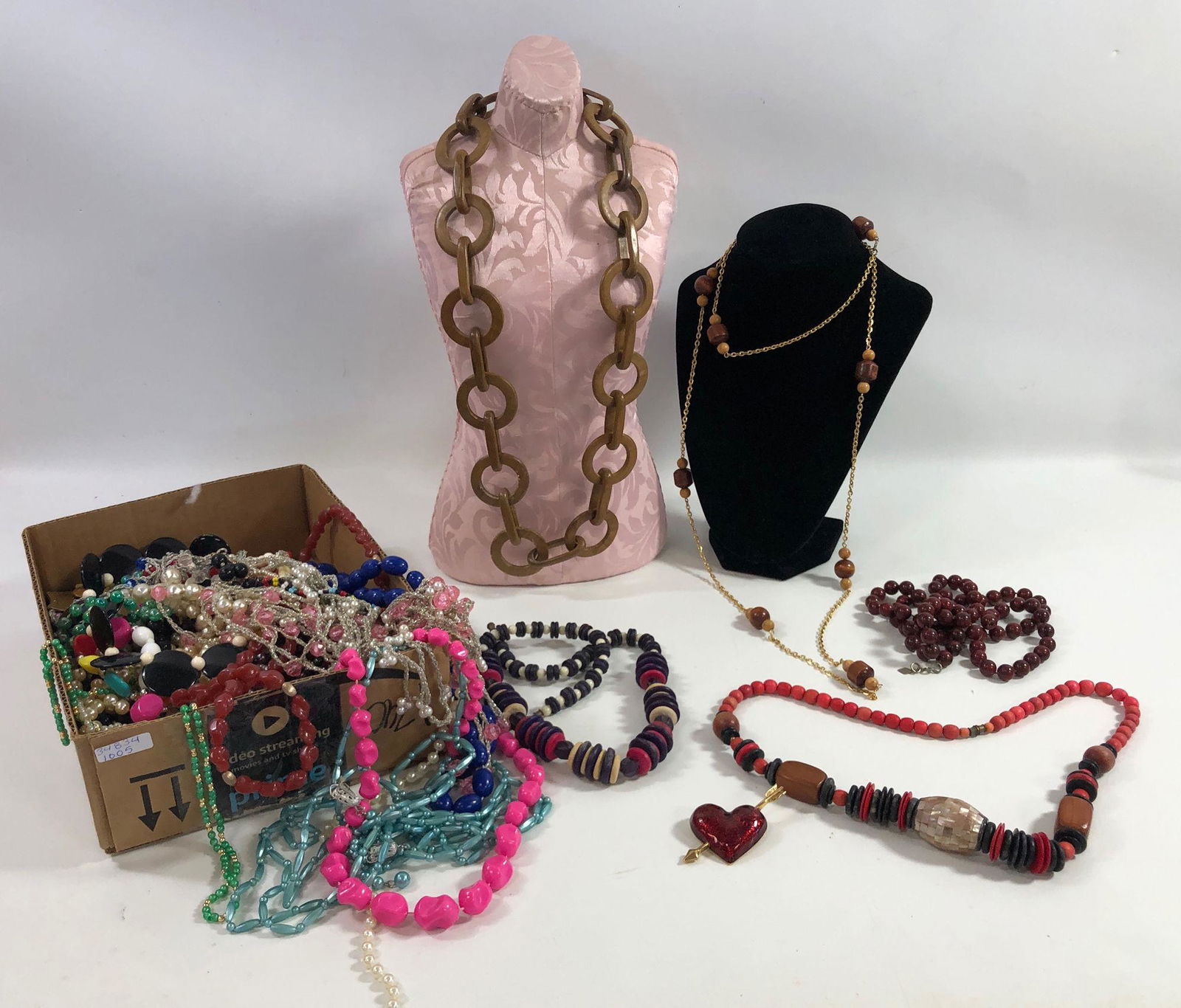 BOX LOT FASHION JEWELRY: BOX LOT FASHION JEWELRY ~ LOT INCLUDES 30" WOODEN NECKLACE W. OBLONG & ROUND LINKS FEAT. HOOK CLASP, APPROX. 2.5" GOLD TONE HEART WITH ARROW PIN FROM AVON, 24" NECKLACE W/ CHECKERED MOP CENTER BEAD, 2