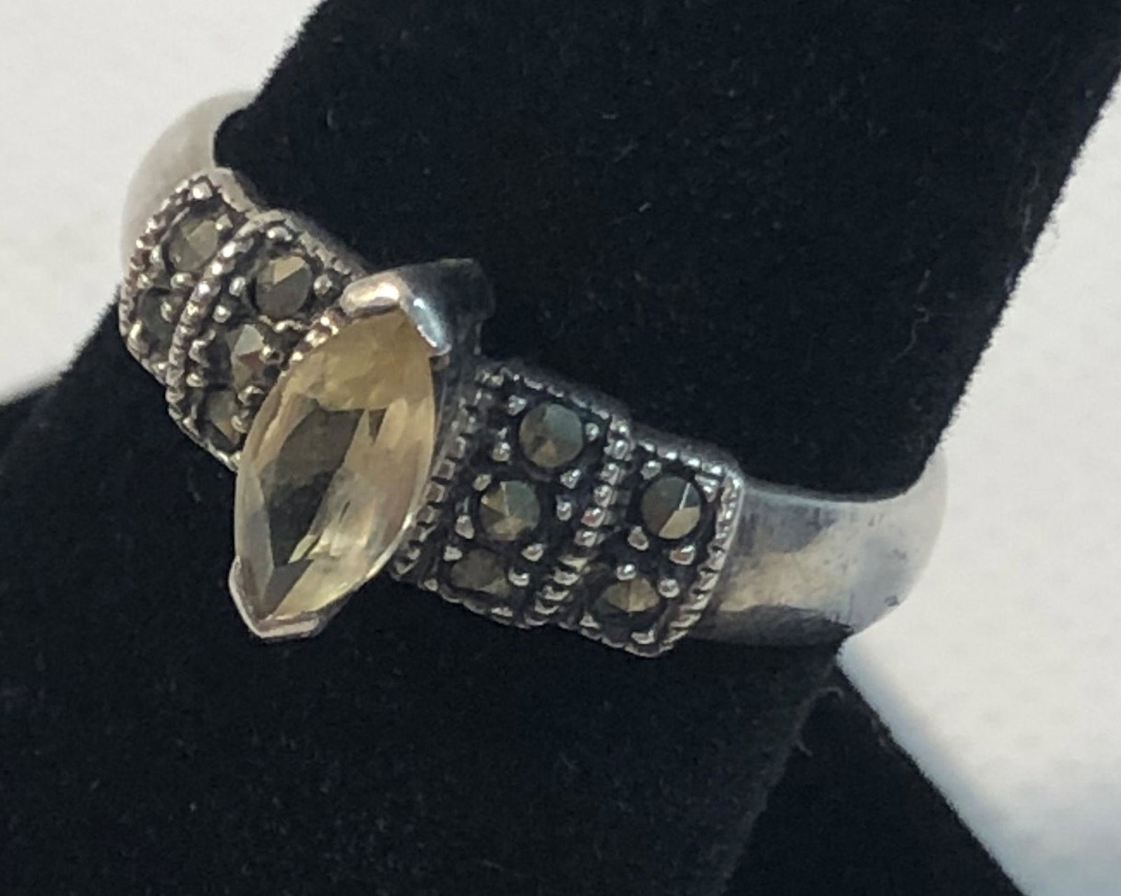 STERLING SILVER AND SEMI-PRECIOUS STONE RING: STERLING SILVER AND SEMI-PRECIOUS STONE RING ~ SIZE 7.5 TAPERED SHANK RING W/ MARQUISE CUT LIGHT YELLOW STONE SURROUNDED BY MARCASITE ACCENT STONES, STAMPED AND TESTED (0.90 TROY OZ TW)