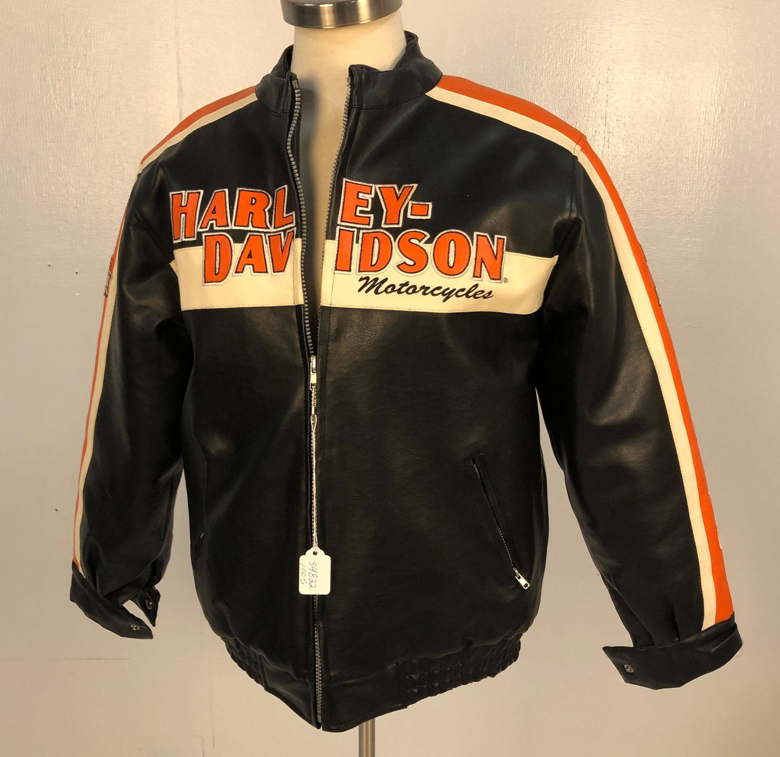 LADIES HARLEY DAVIDSON JACKET: LADIES HARLEY DAVIDSON JACKET ~ SIZE L (16-18), DESIGN FEATURES BLACK BODY WITH BRANDED FRONT AND BACK IN CREME, AND ORANGE, ZIPPED CLOSURE, BACK FEATURES HD LOGO