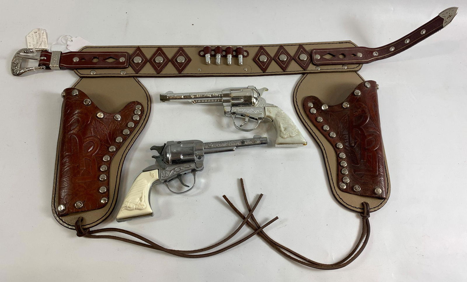 ROY ROGERS BROWN AND TAN LEATHER DOUBLE HOLSTER SET: ROY ROGERS BROWN AND TAN LEATHER DOUBLE HOLSTER SET WITH (2) KILGORE ROY ROGERS CAP GUNS.
