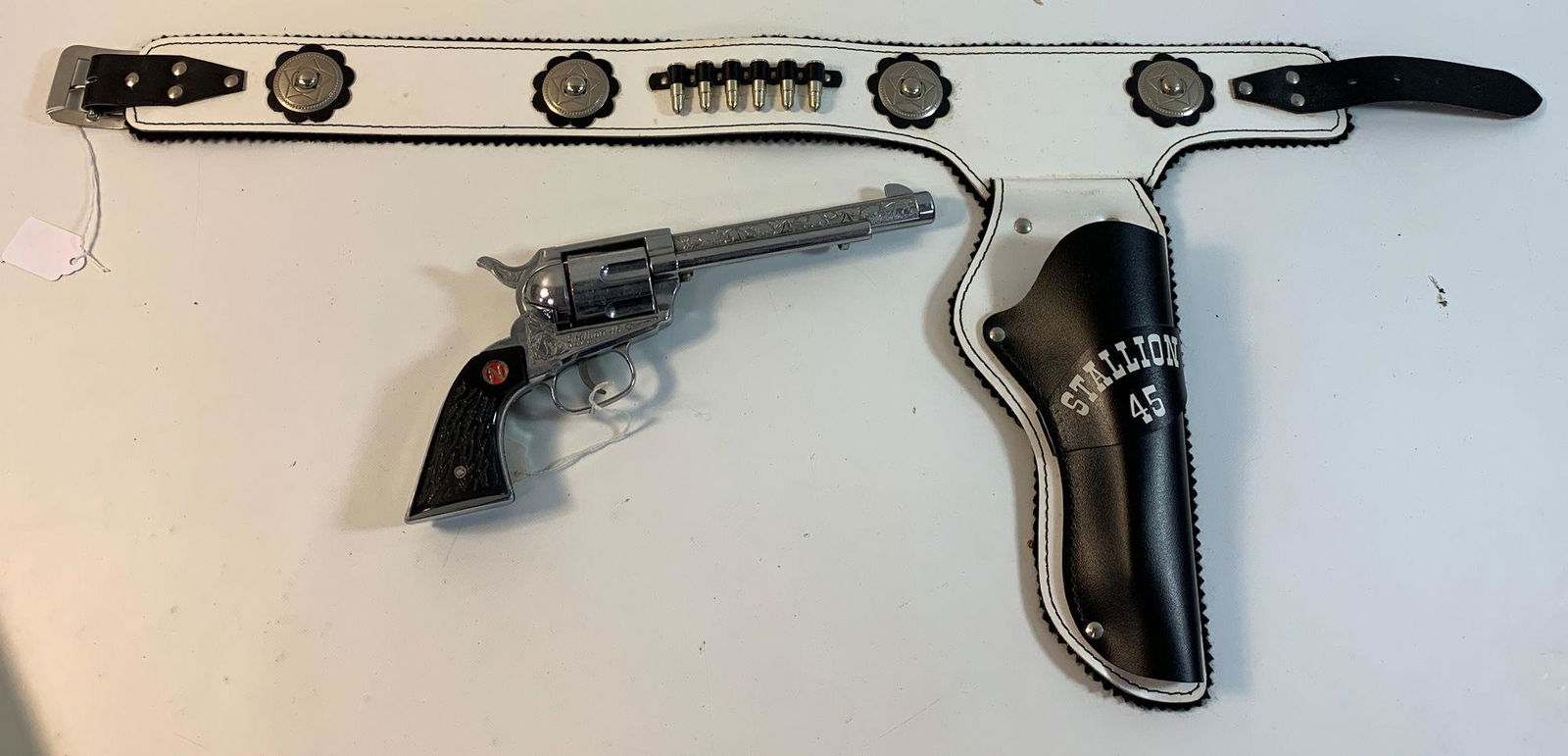 1960's NICHOLS "STALLION" 45 MARK II ENGRAVED AND: 1960's NICHOLS "STALLION" 45 MARK II ENGRAVED AND REVOLVING CYLINDER CAP GUN AND REPRODUCTION STALLION 45 BLACK AND WHITE LEATHER SINGLE HOLSTER WITH BULLETS