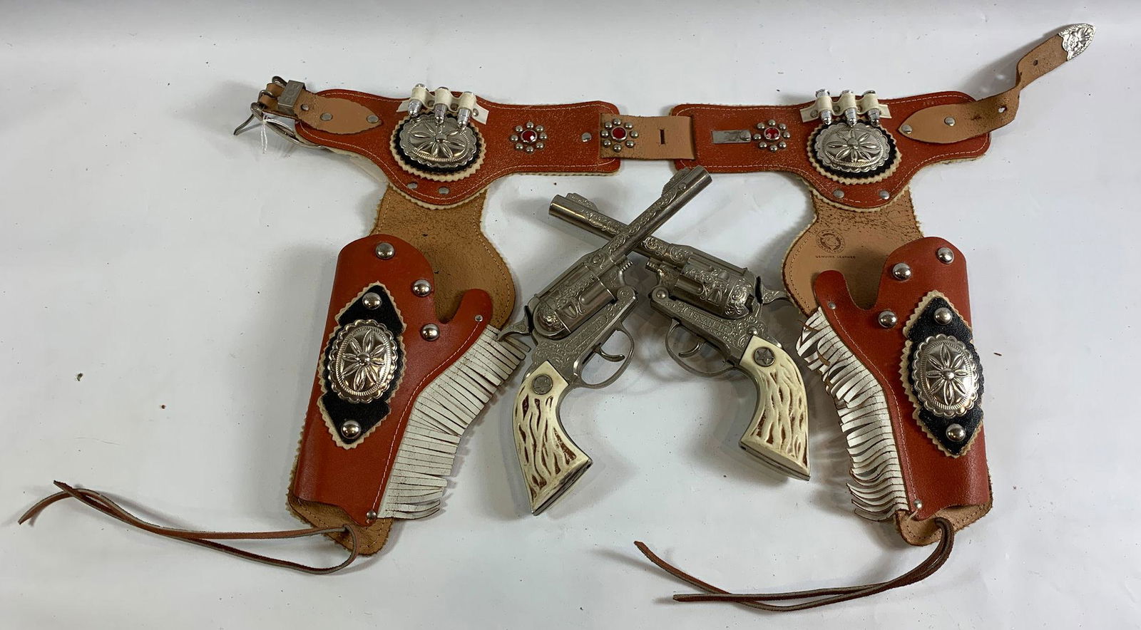 BROWN DOUBLE LEATHER HOLSTER SET WITH BLACK LEATHER AND: BROWN DOUBLE LEATHER HOLSTER SET WITH BLACK LEATHER AND SILVER CONCHOS, RED JEWELS AND SILVER STUDS AND TWO HUBLEY TEXAN JR. CAP GUNS