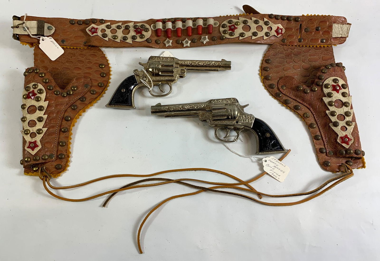 1950's BROWN AND WHITE LEATHER S-BAR-M DOUBLE HOLSTER: 1950's BROWN AND WHITE LEATHER S-BAR-M DOUBLE HOLSTER SET AND TWO 1940's STEVENS "PEACE MAKER" GOLD FINISH CAP GUNS