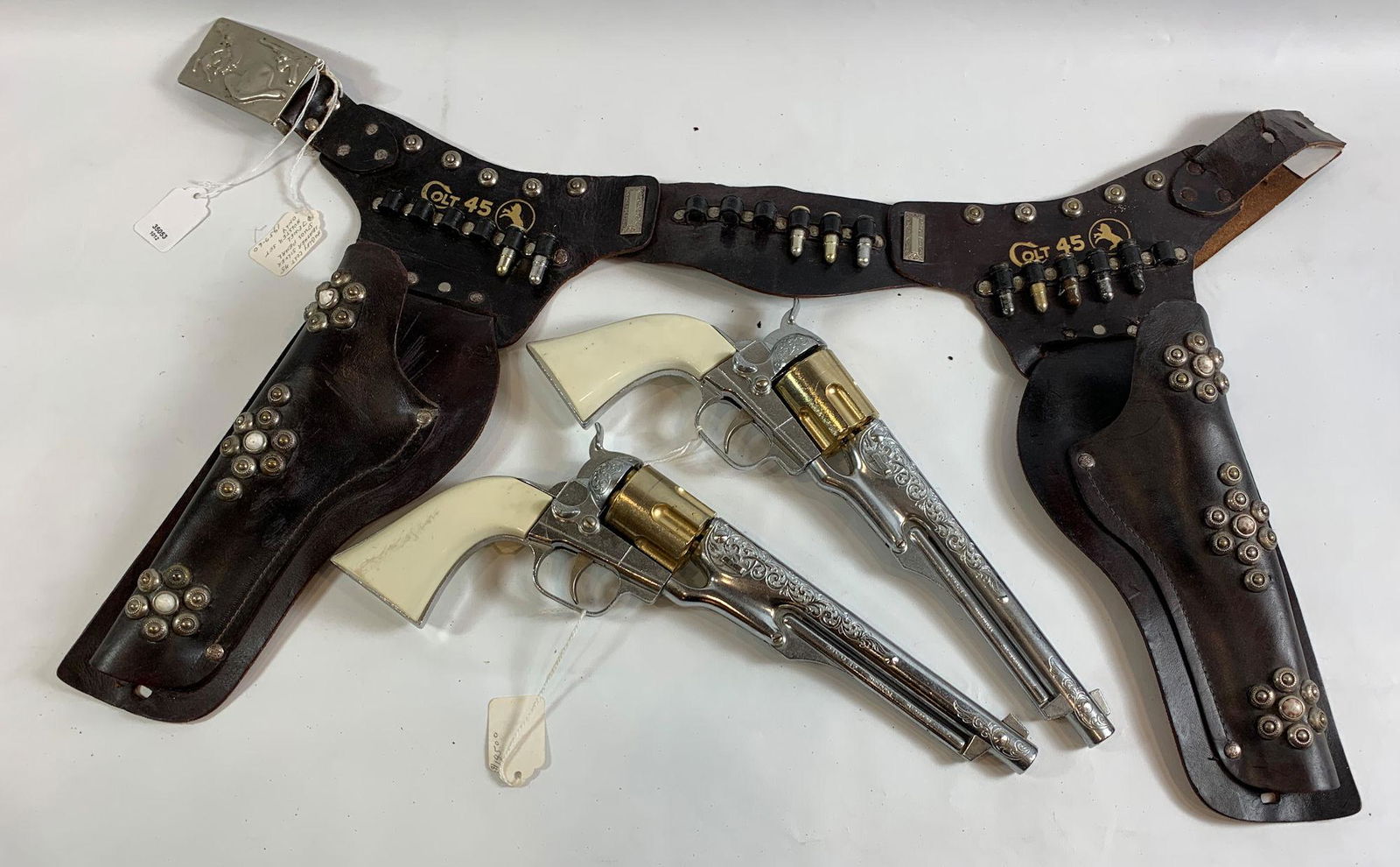 1950's BLACK LEATHER COLT 45 HOLSTER SET WITH SILVER: 1950's BLACK LEATHER COLT 45 HOLSTER SET WITH SILVER STUDS, WHITE JEWELS AND PAIR OF HUBLEY COLT 45 CAP GUNS WITH WHITE GRIPS