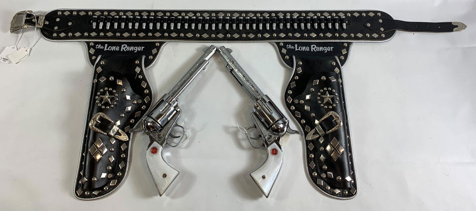 THE LONE RANGER BLACK LEATHER DOUBLE HOLSTER SET,: THE LONE RANGER BLACK LEATHER DOUBLE HOLSTER SET, SILVER STUDS AND BULLETS IN BELT AND PAIR OF 1950's NICHOLS STALLION 45 MARK II CAP GUNS WITH REVOLVING CYLINDERS, BULLETS AND PEARL GRIPS