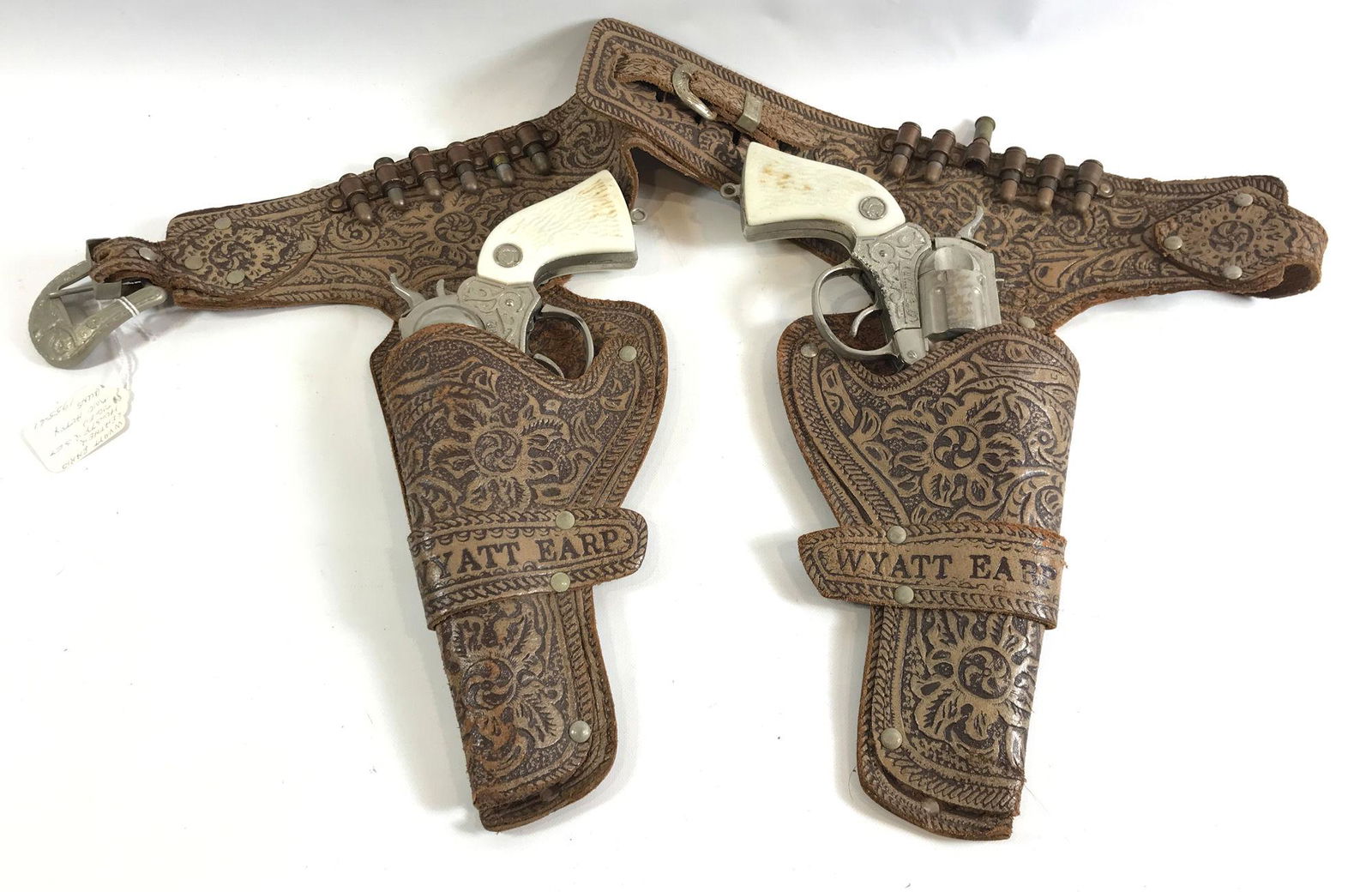 WYATT EARP BROWN TOOLED LEATHER DOUBLE HOLSTER SET WITH: WYATT EARP BROWN TOOLED LEATHER DOUBLE HOLSTER SET WITH BULLETS AND PAIR 1955-61 ACTOY WYATT EARP CAP GUNS